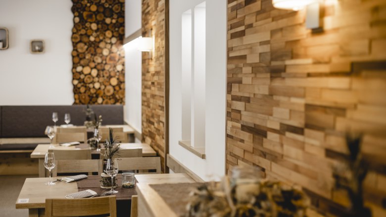 Szeretettel díszített a háziasszony, © Niederösterreich Werbung/David Schreiber Hangulatos étterem fából készült falakkal és díszített asztalokkal.