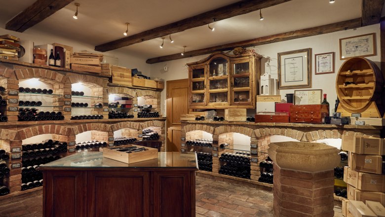 Különleges házi bor, borszaküzlet, © Niederösterreich Werbung/Andreas Hofer Borospince téglapolcokkal és borosüvegekkel.