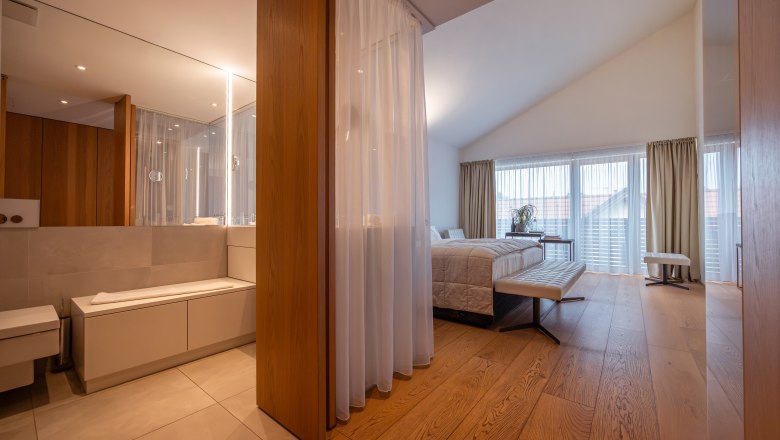 MÖRWALD, Relais Chateaux Hotel am Wagram, © Niederösterreich Werbung / Maximilian Pawlikowsky Modern szállodai szoba fapadlóval, nagy ággyal és tükrös fürdőszobával.