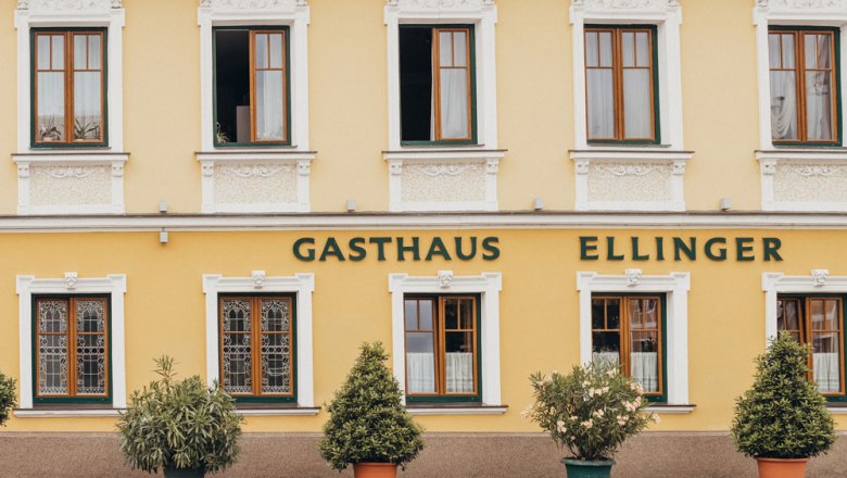 Fogadó St. Peter in der Au-ban, © Niederösterreich Werbung/Daniela Führer Egy sárga színű vendéglő homlokzata "Gasthaus Ellinger" felirattal.
