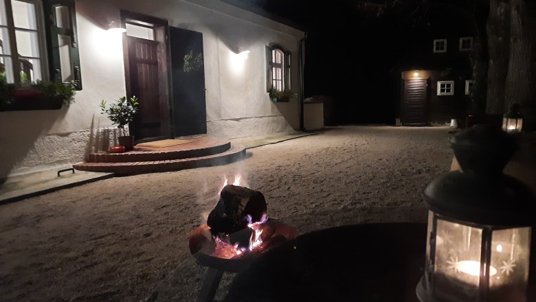 Vidéki birtok Oberhof, © Landsitz Oberhof Éjszakai kivilágított udvar, előtérben tűzkosárral és lámpással.