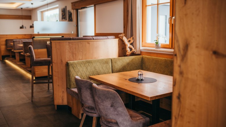 Étterem, © Niederösterreich Werbung/Daniela Führer Hangulatos étkező, fabútorokkal és kárpitozott padokkal, függönyös ablak, asztal só- és borsszóróval.