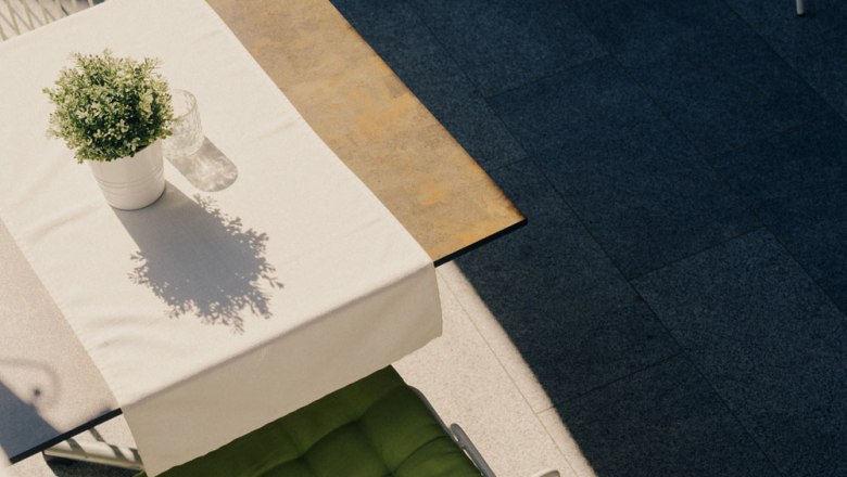 A vendégkert találkozik a gyógynövénykerttel, © Niederösterreich Werbung/Julius Hirtzberger Egy fehér terítővel letakart asztal, cserepes növény és üveg kívül.