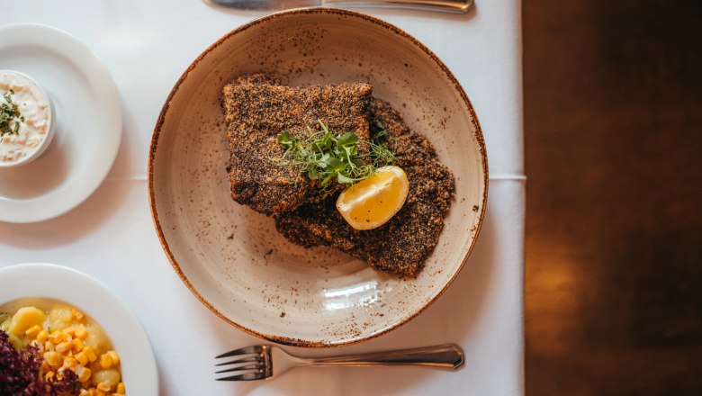Waldvierteli pontyfilé a Zwettl apátságból szürke mákkal panírozva, © Niederösterreich Werbung/Daniela Führer Szürke mákos rántott pontyfilé citromszelettel és fűszernövényekkel tányéron, köretekkel.