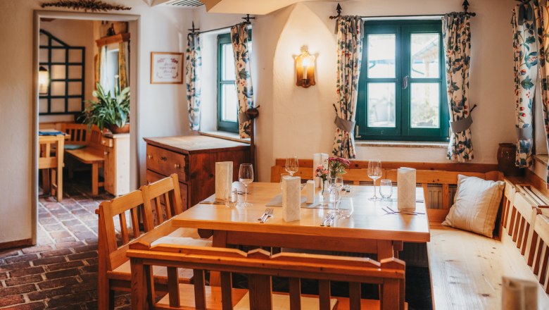 Az étterem hangulatos hely az étkezéshez., © Niederösterreich Werbung/Daniela Führer Hangulatos szalon fából készült bútorokkal és terített asztallal.