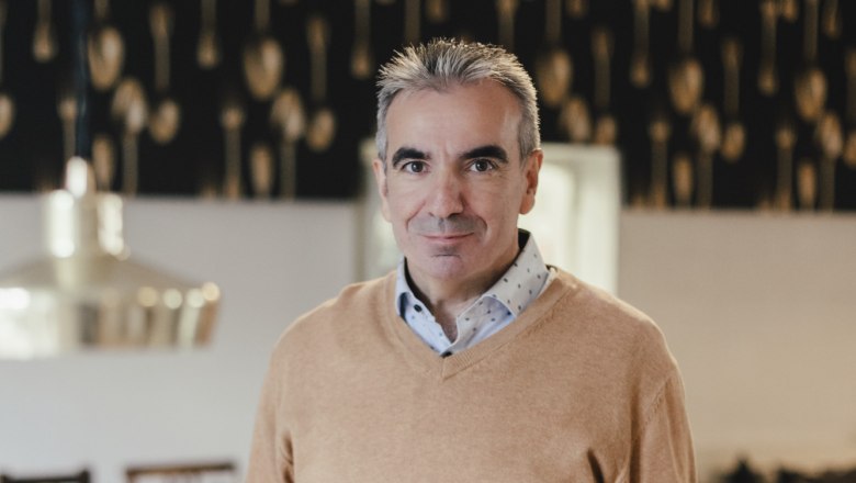 Házigazda és sommelier Martin Blauensteiner, © Niederösterreich Werbung/David Schreiber Egy férfi egy étteremben egy tányér ételt tart a kezében.