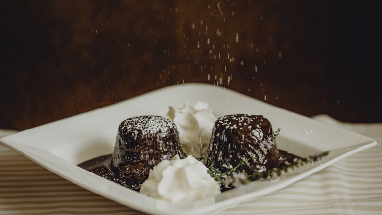 Mór ingben, © Niederösterreich Werbung/Sophie Menegaldo Két csokoládétorta porcukorral és tejszínnel egy tányéron.