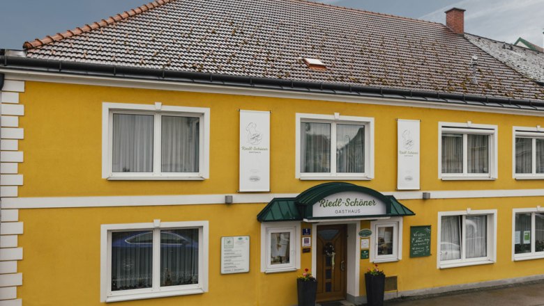 Kocsma sok bio termékkel, © Niederösterreich Werbung/David Schreiber Sárga vendégház zöld napellenzővel és több ablakkal.