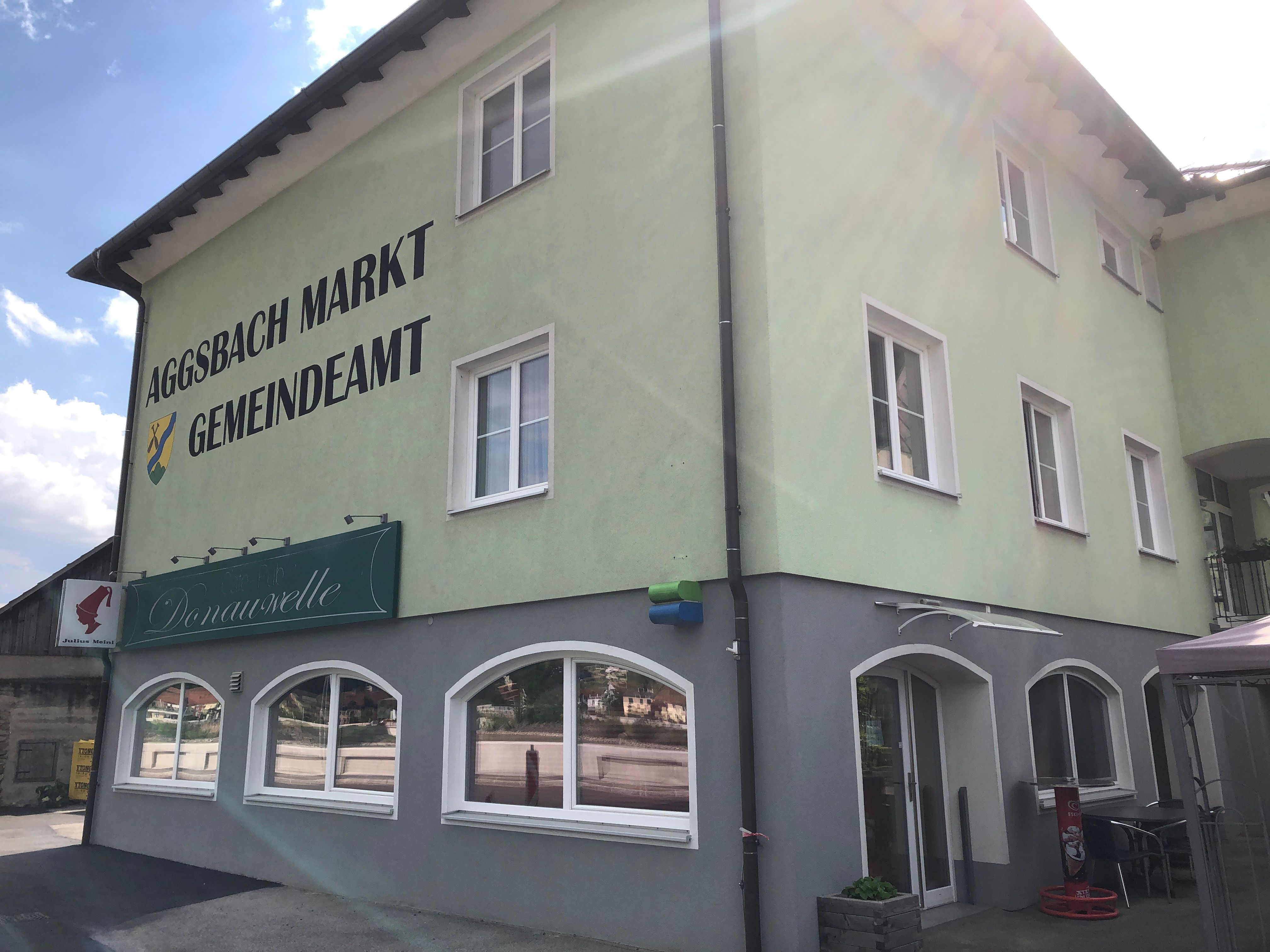 "Aggsbach Markt Gemeindeamt" feliratú zöld épület és a Café Donauwelle.