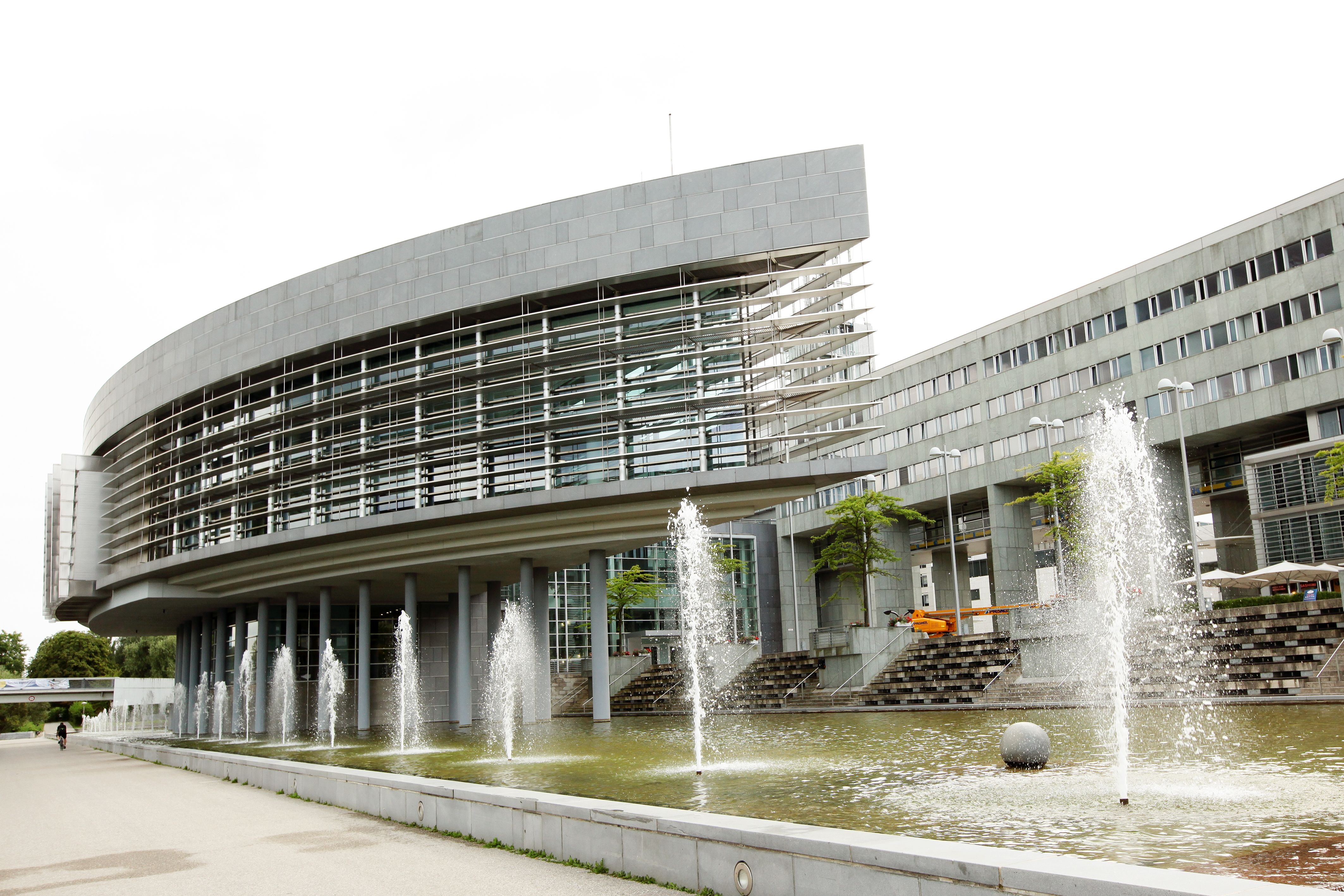 A Landhaus St. Pölten modern épületszerkezetekkel és egy szökőkúttal az előtérben.