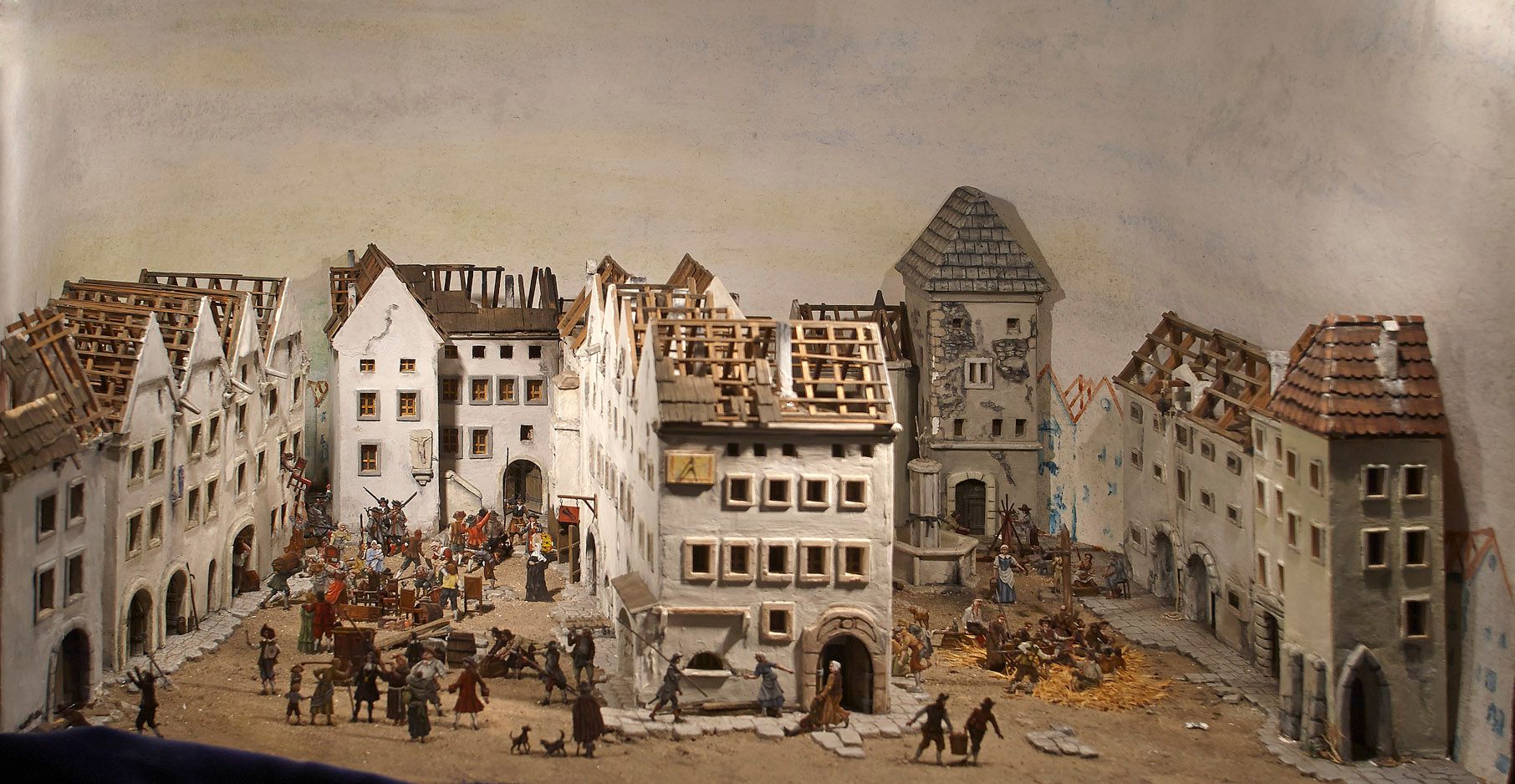 Miniatűr város figurákkal történelmi környezetben.