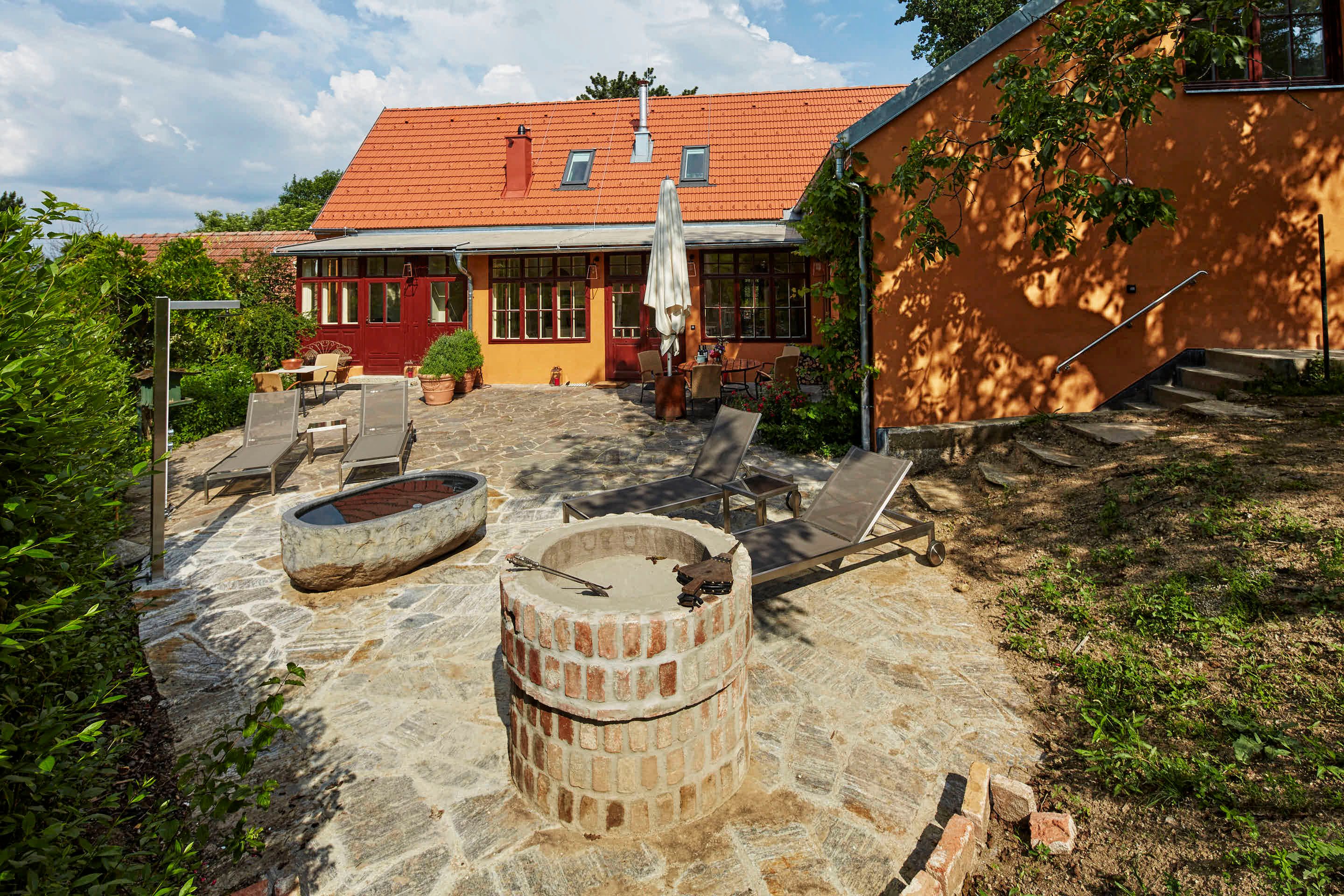 Egy villa terasza nyugágyakkal és kandallóval.