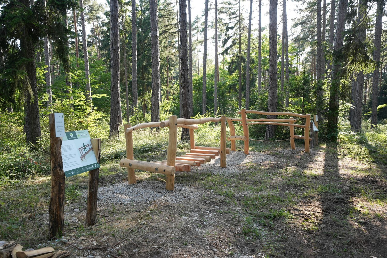Fából készült felszerelés az erdőben, információs táblával a Göttweig gyógyító erdőben.