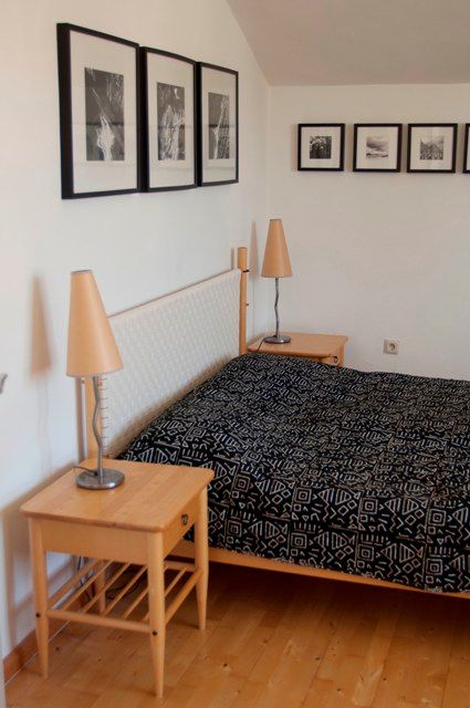 Hálószoba franciaággyal, éjjeliszekrényekkel és faliképekkel.