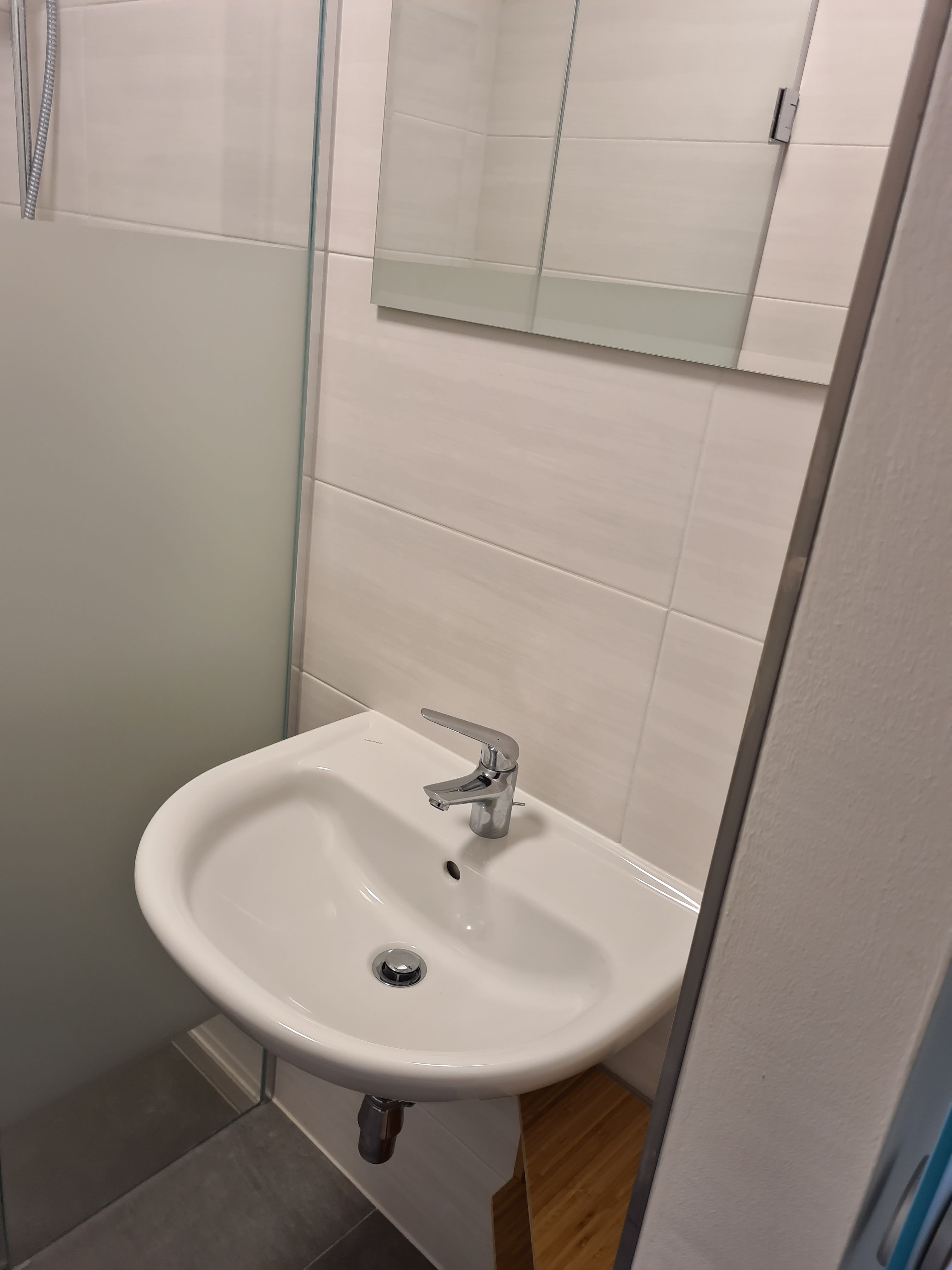 Modern fürdőszoba mosdóval és tükörrel.