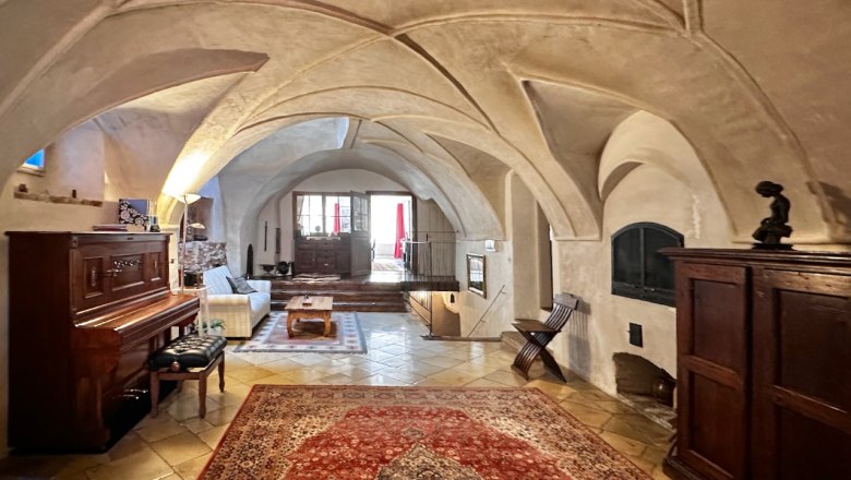 T&ouml;rt&eacute;nelmi fogad&oacute;terem bolt&iacute;ves mennyezettel, szőnyeggel, zongor&aacute;val &eacute;s fab&uacute;torokkal.