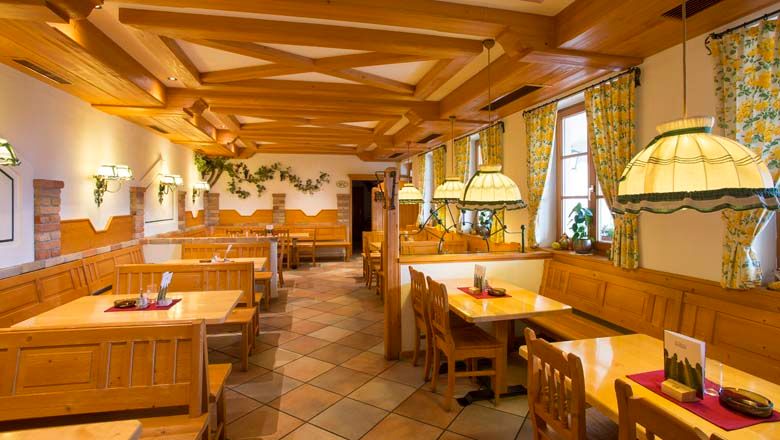 Egy hagyományos borozó belső nézete, fa bútorokkal és hangulatos világítással.