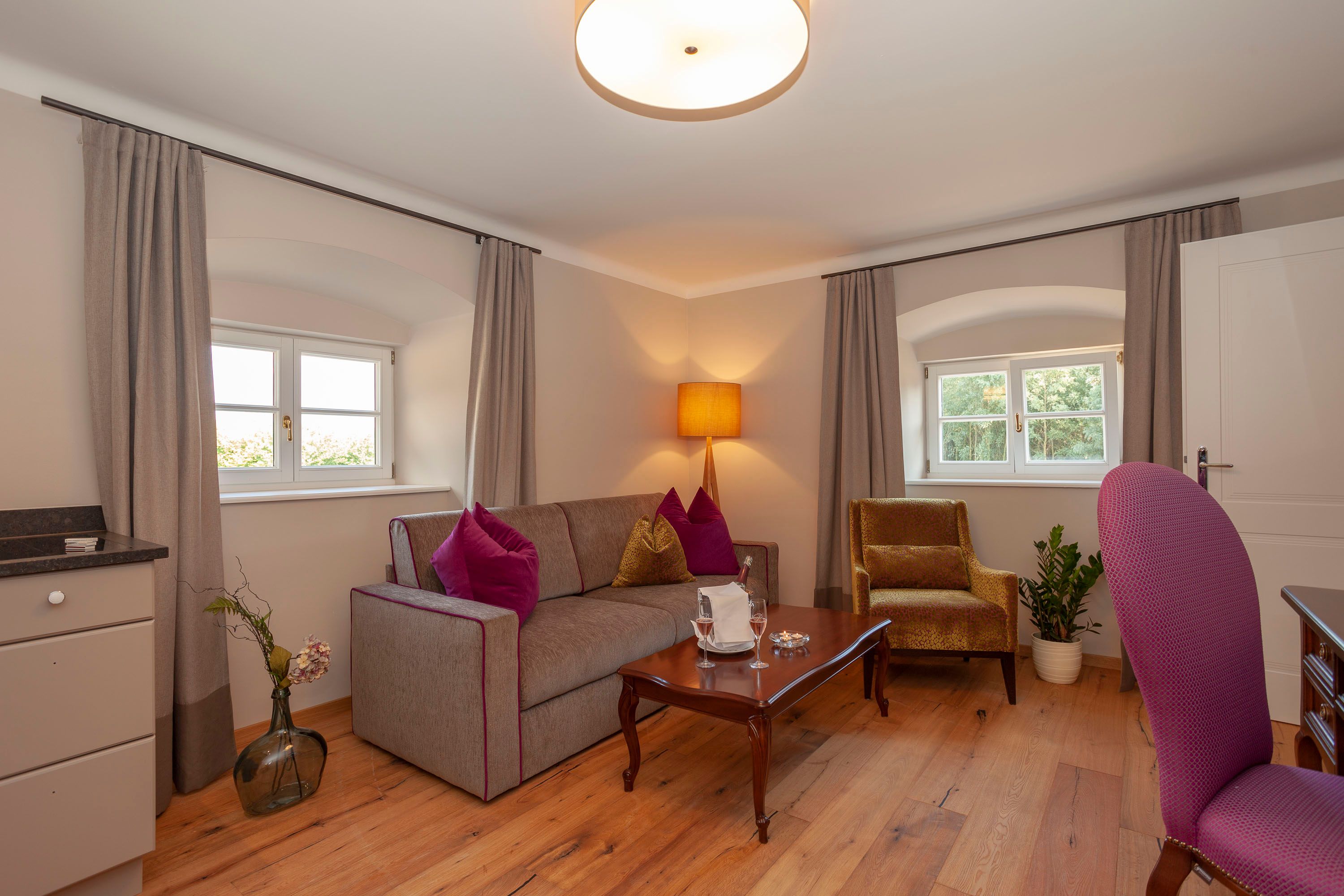 Elegáns lakosztály kanapéval, karosszékkel, asztallal és dekorációval.