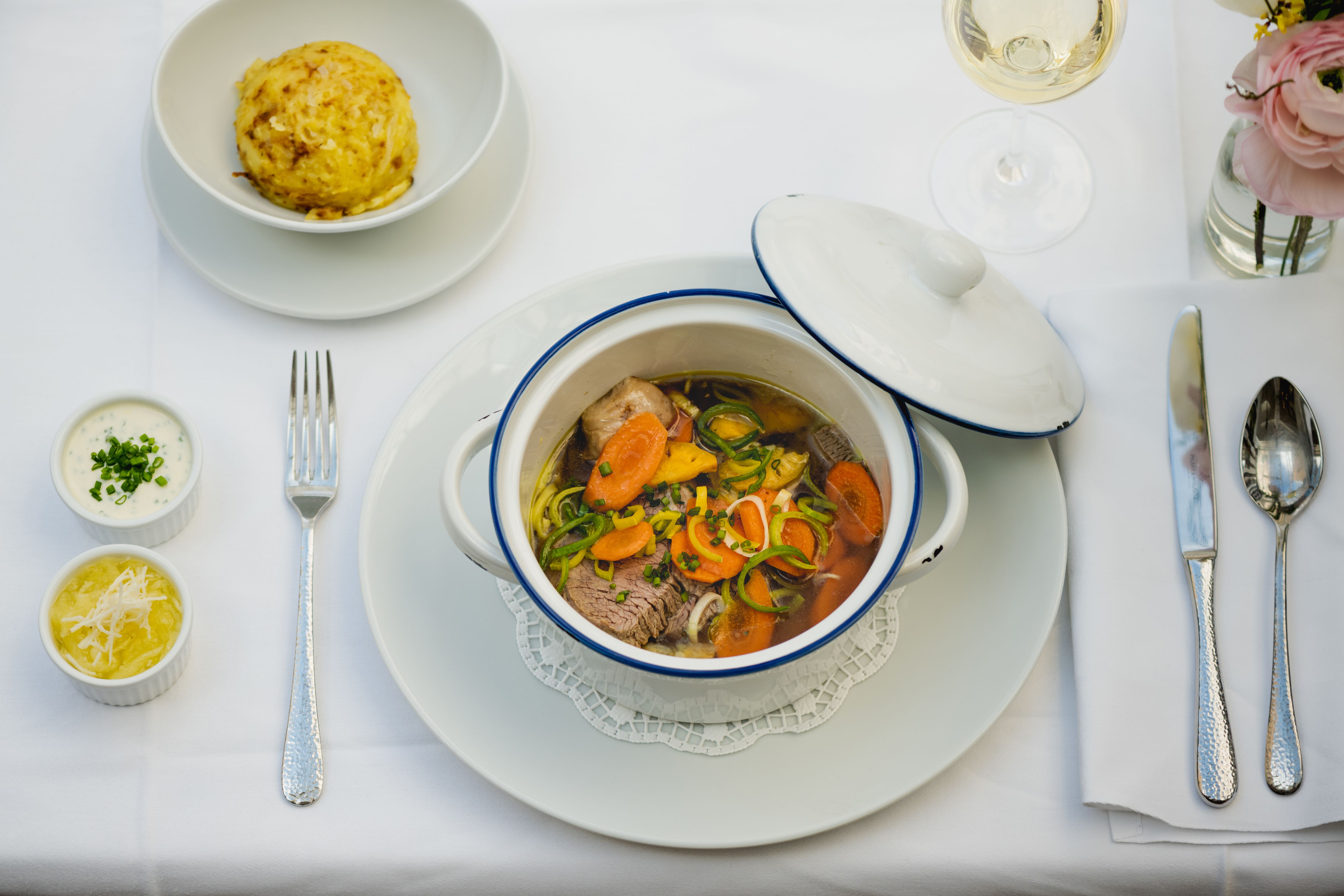 A terített asztalra fehér fazékban pörkölt, gombóc, két mártás és egy pohár fehérbor került.