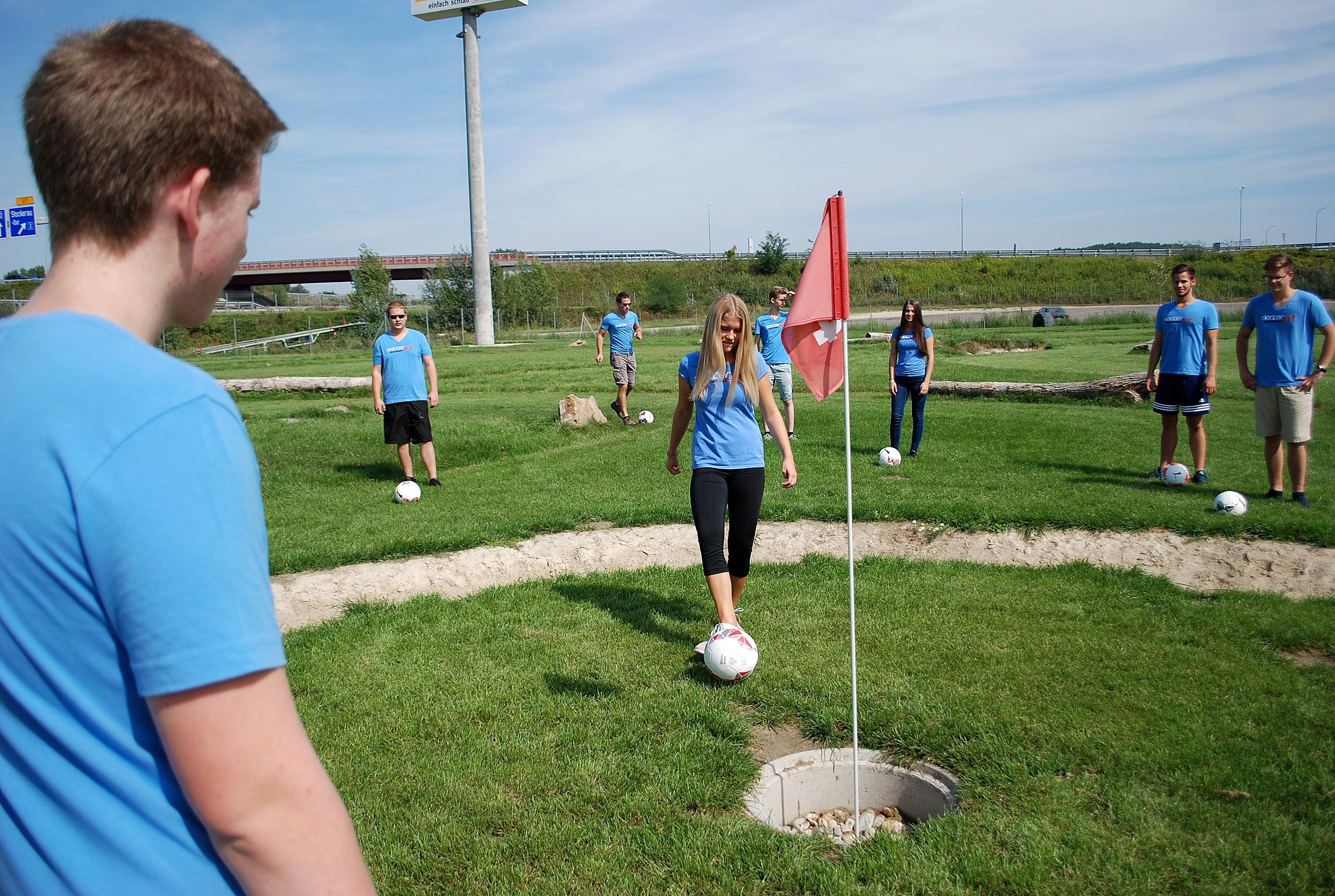 Fiatalok egy csoportja Soccergolfot játszik.