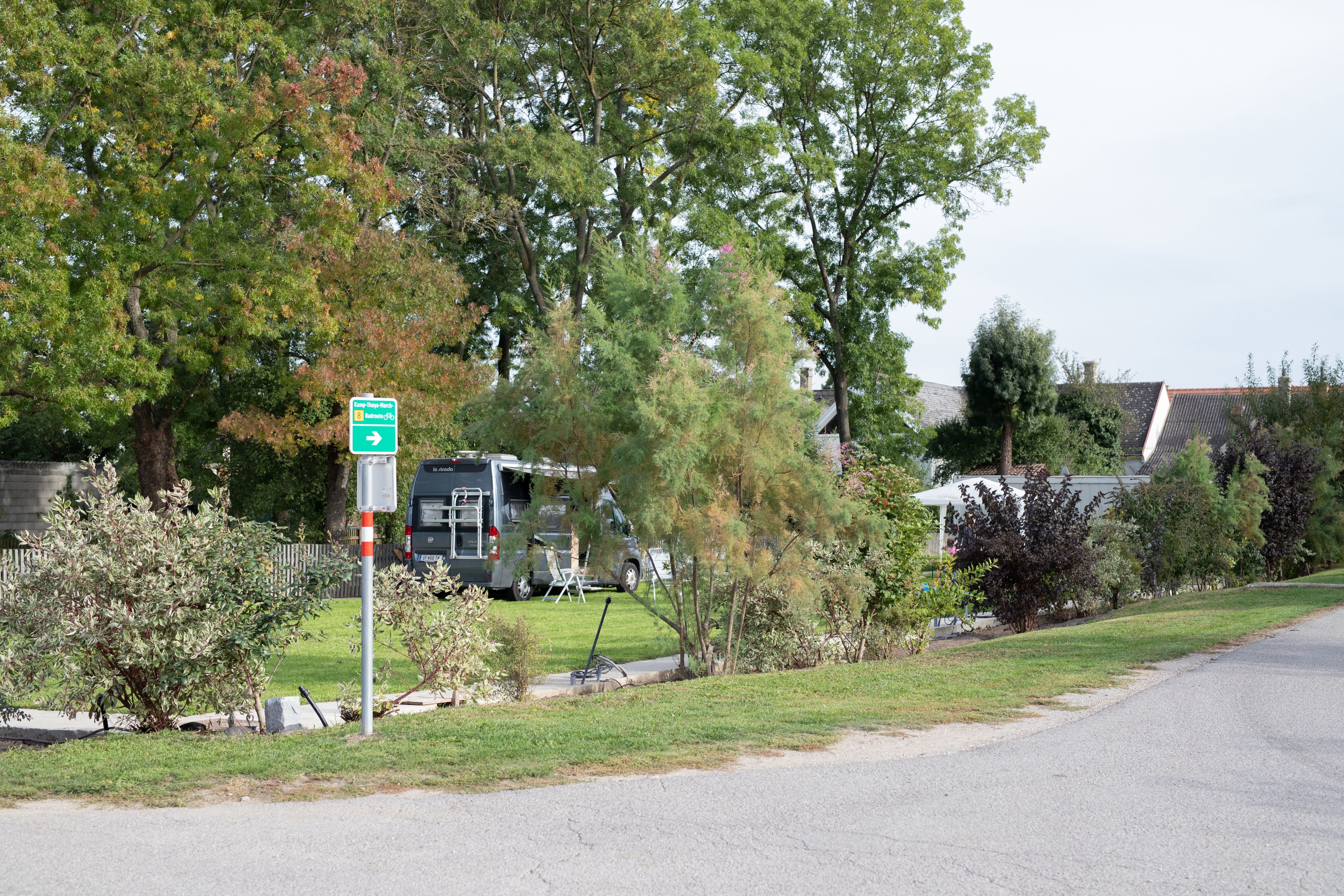 Kemping lakóautóval és fákkal a háttérben.
