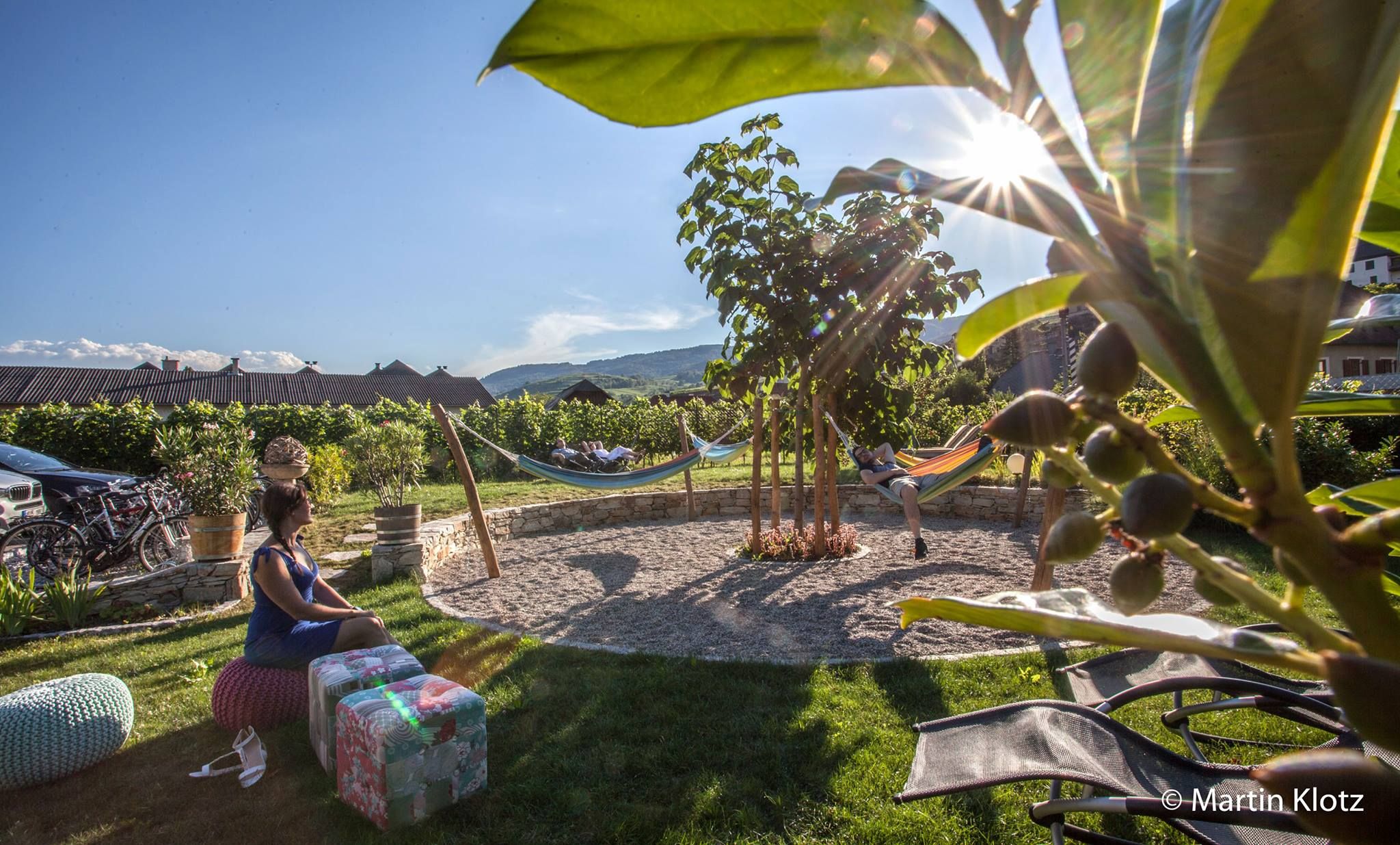 Mediterrán kert függőágyakkal és pihenő emberekkel.