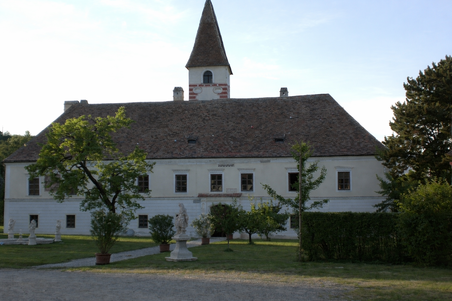 Limbergi kastély, előtérben a kert és a szobrok.