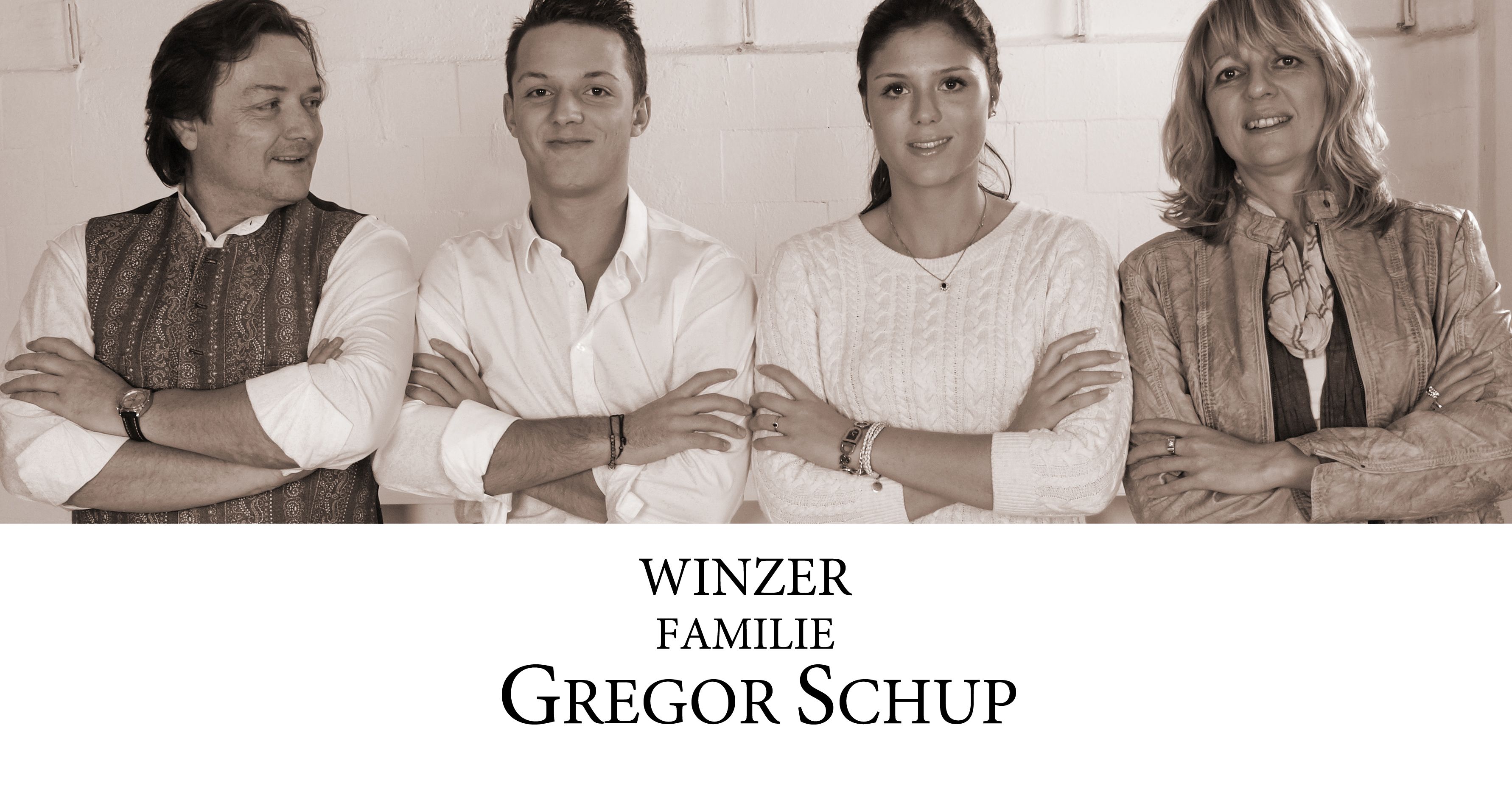Négy ember áll egymás mellett, mosolyogva, keresztbe tett karral. Alattuk a "Winzer Familie Gregor Schup" felirat olvasható.
