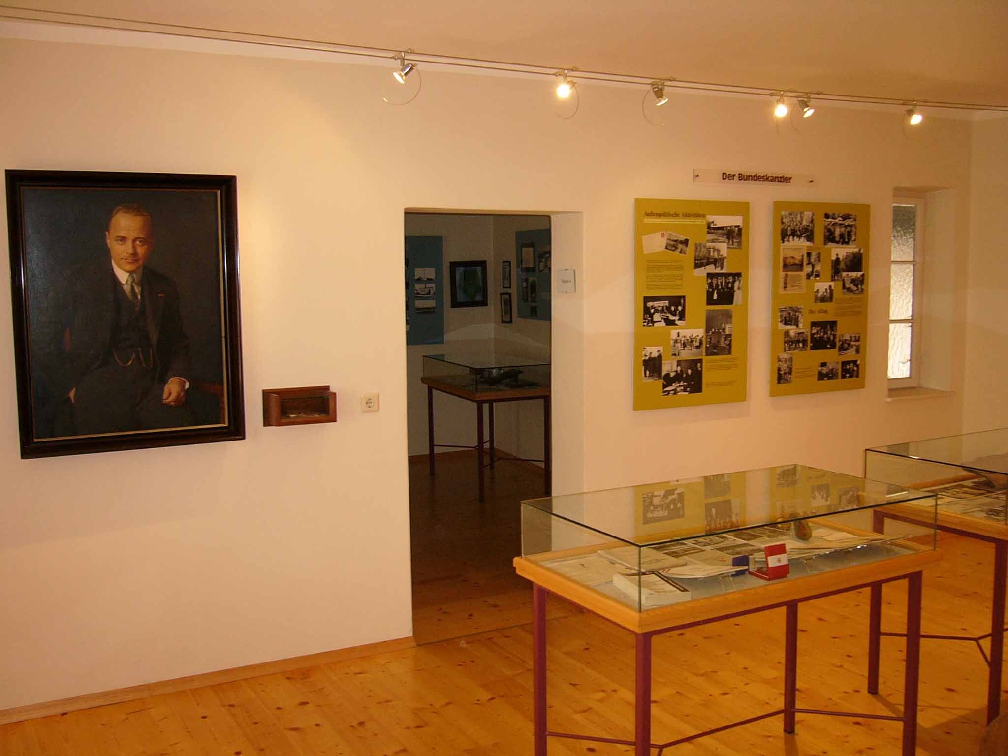Egy múzeum belső nézete portréval és kiállítási táblákkal.
