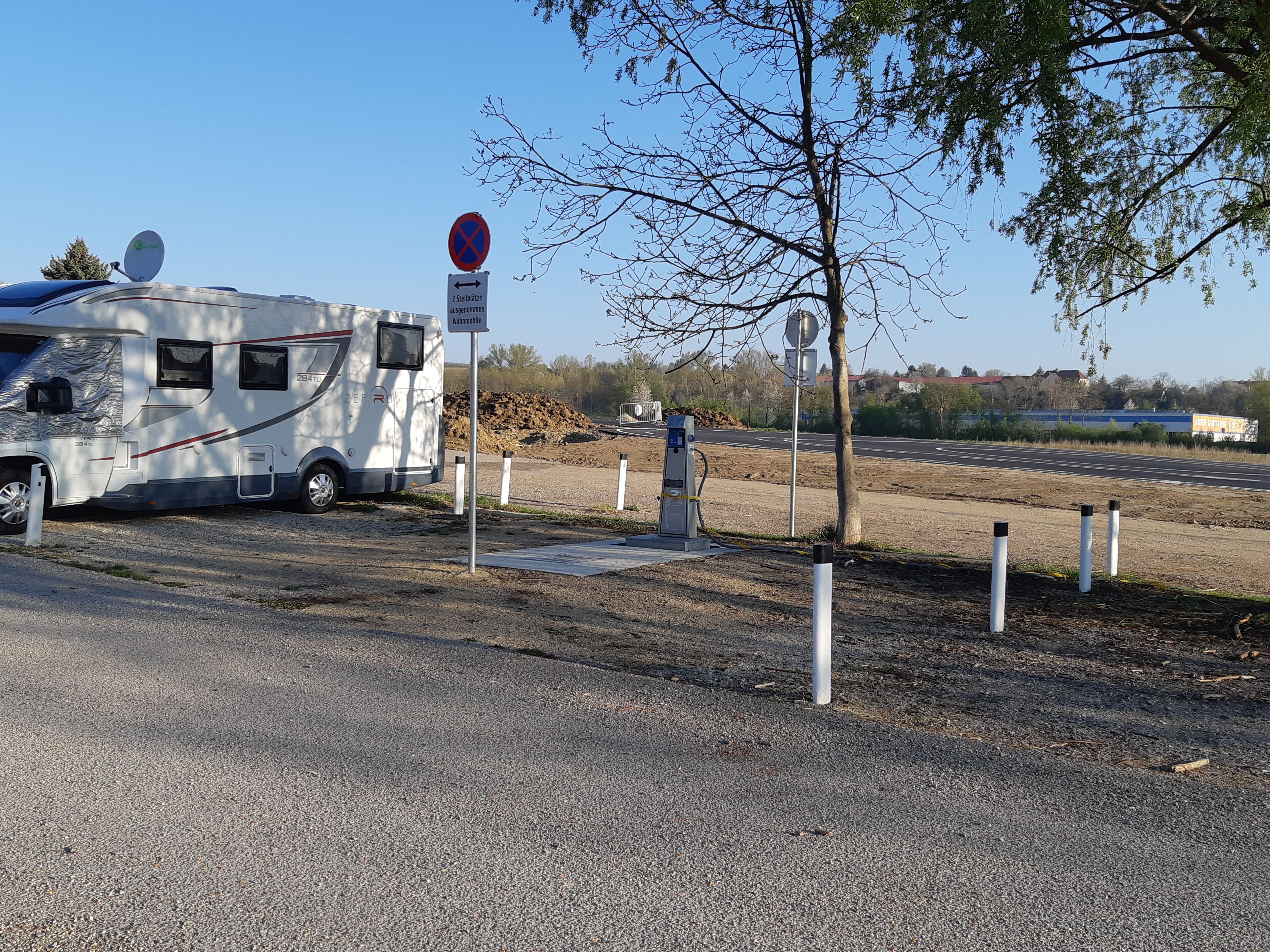 Lakóautó egy táblákkal és fákkal tarkított pályán.