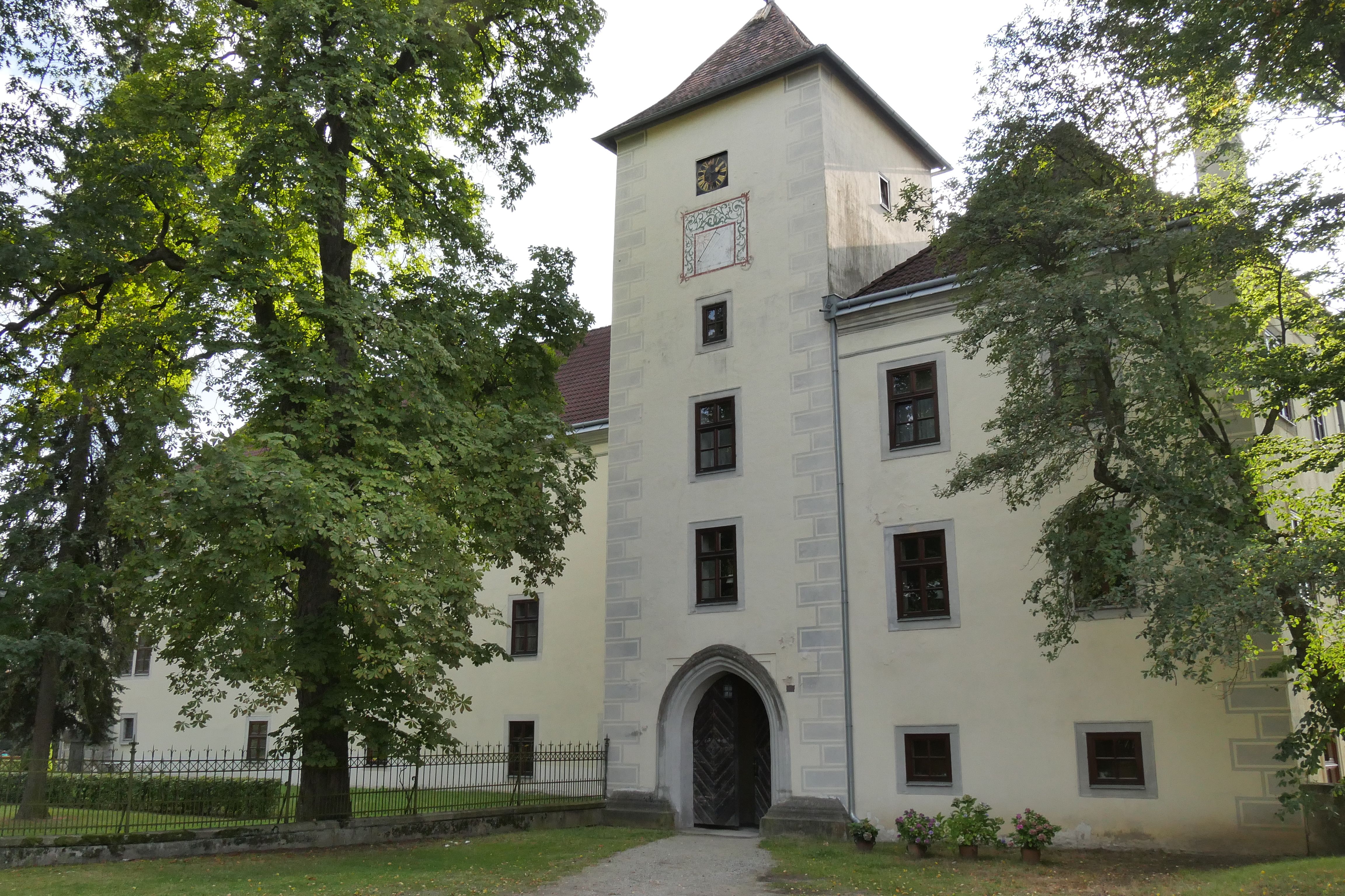Történelmi épület toronnyal és fákkal az előtérben.