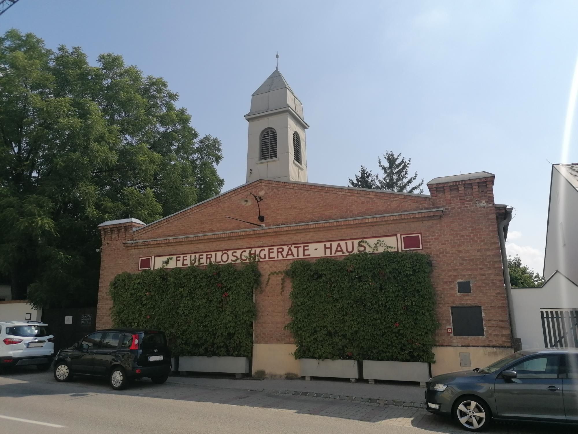 Régi tűzoltóállomás Bad Fischau-ban, tégla homlokzattal és toronnyal.