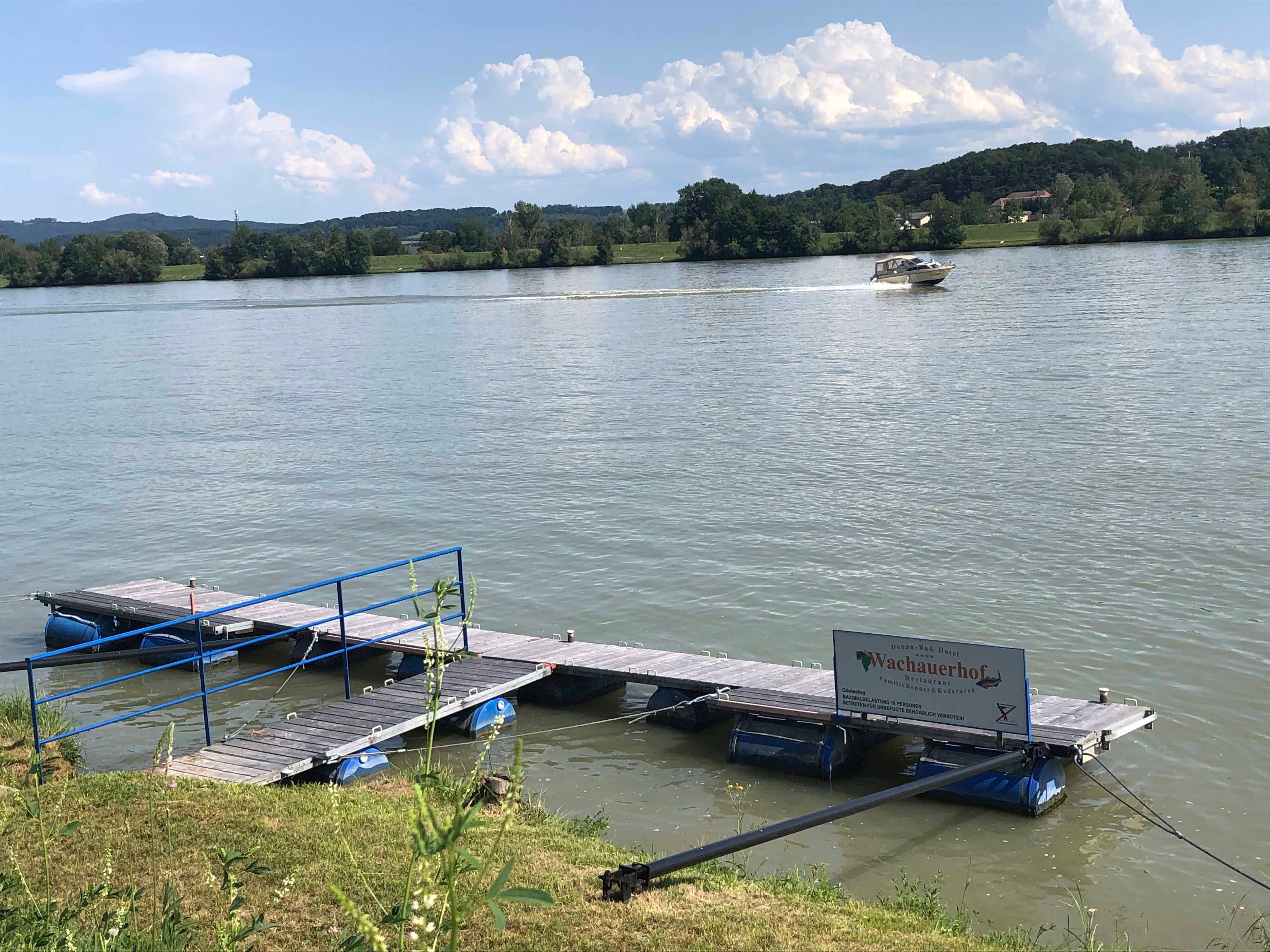 Móló a folyón, a háttérben csónakkal.