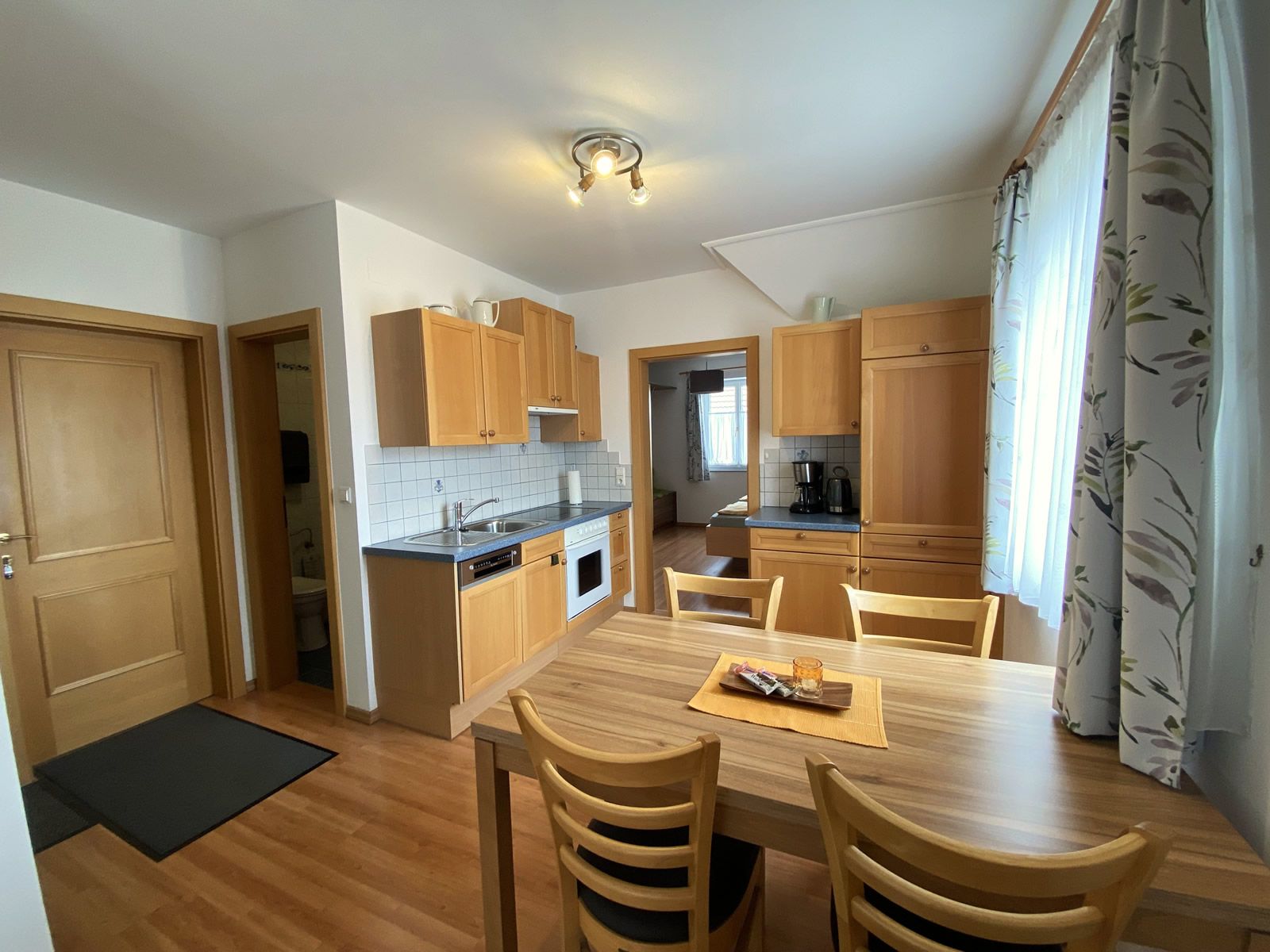 Egy nyaraló lakás belső nézete konyhával és étkezőasztallal.