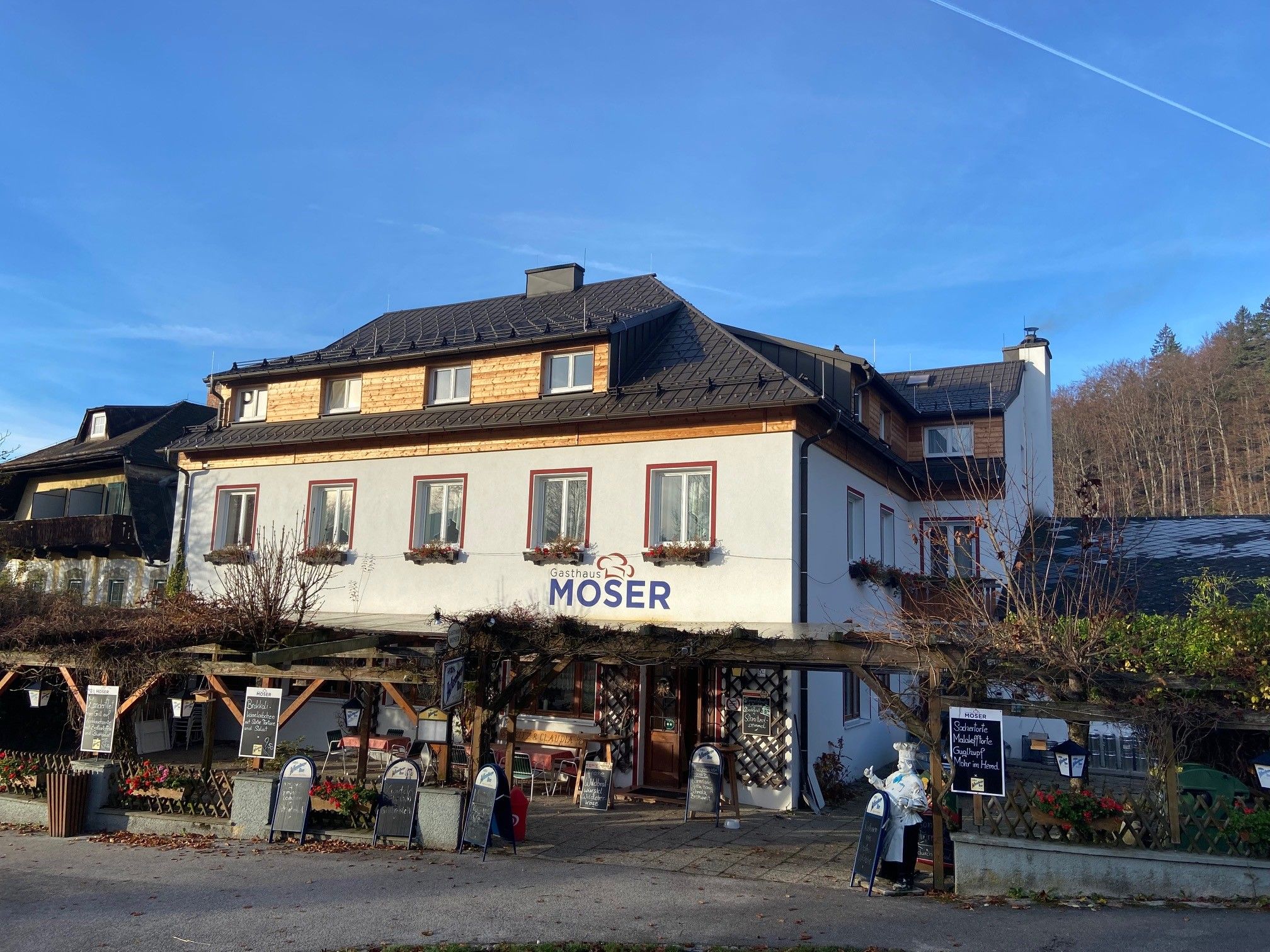 Gasthaus Moser, terasz és kék ég a háttérben.