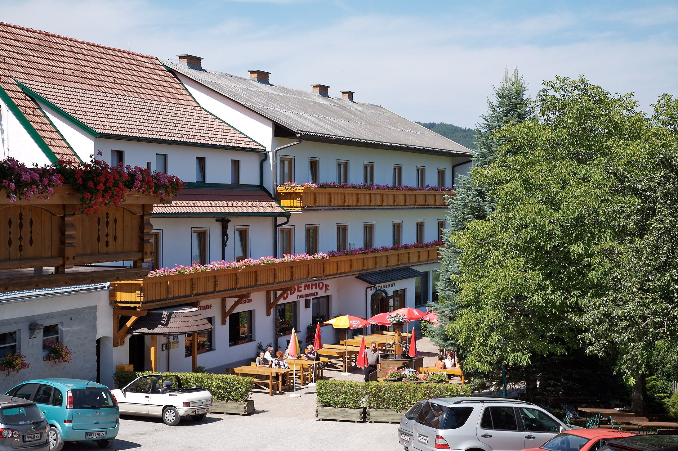 Gasthof-Pension Ödenhof terasszal és parkoló autókkal.