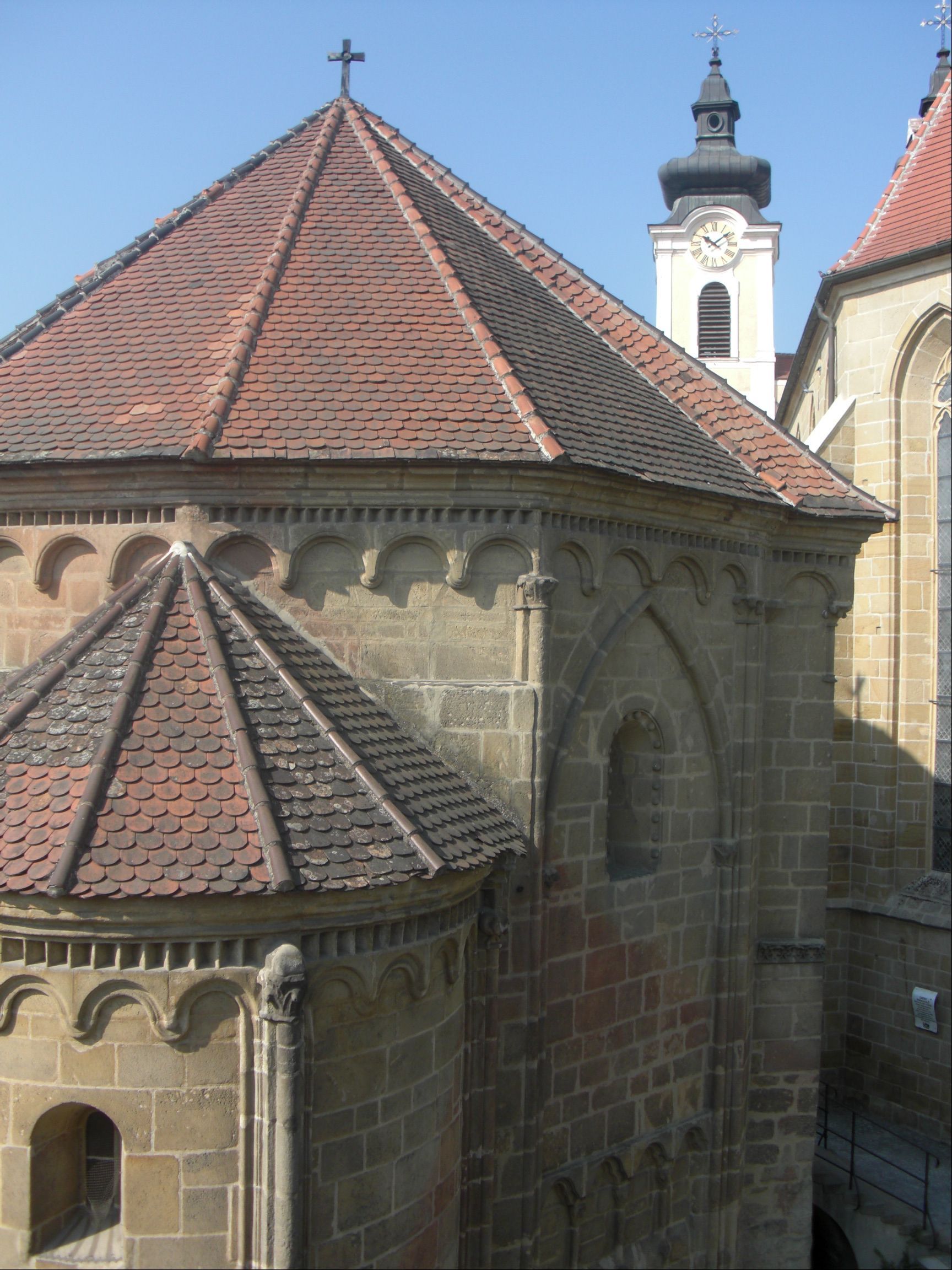 Tullni koporsóház román stílusú építészettel és templomtoronnyal a háttérben.