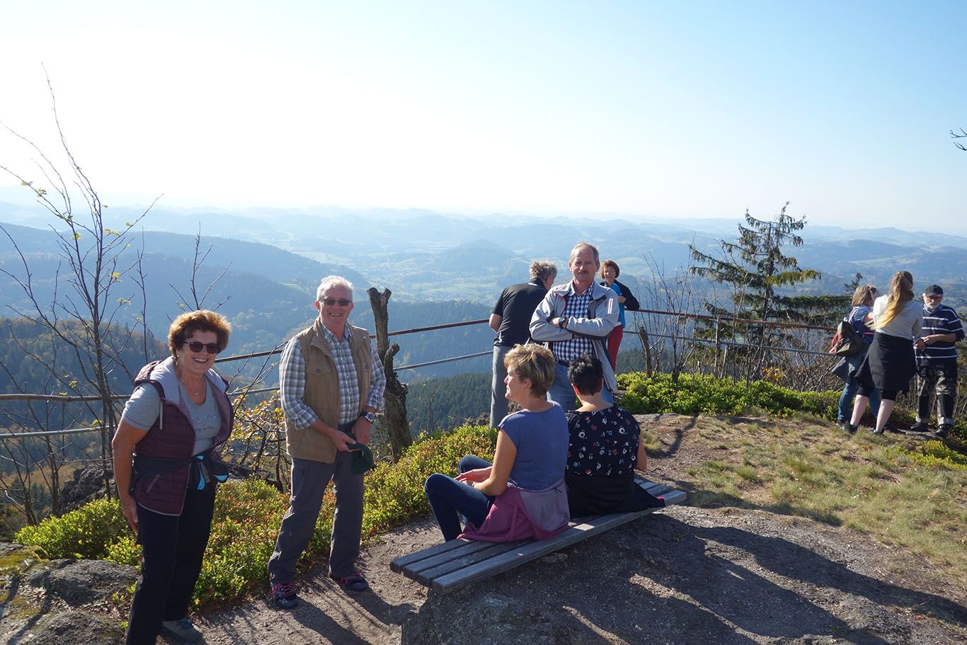 Az emberek élvezik a kilátást egy hegytetőről, ahonnan széles kilátás nyílik a tájra.