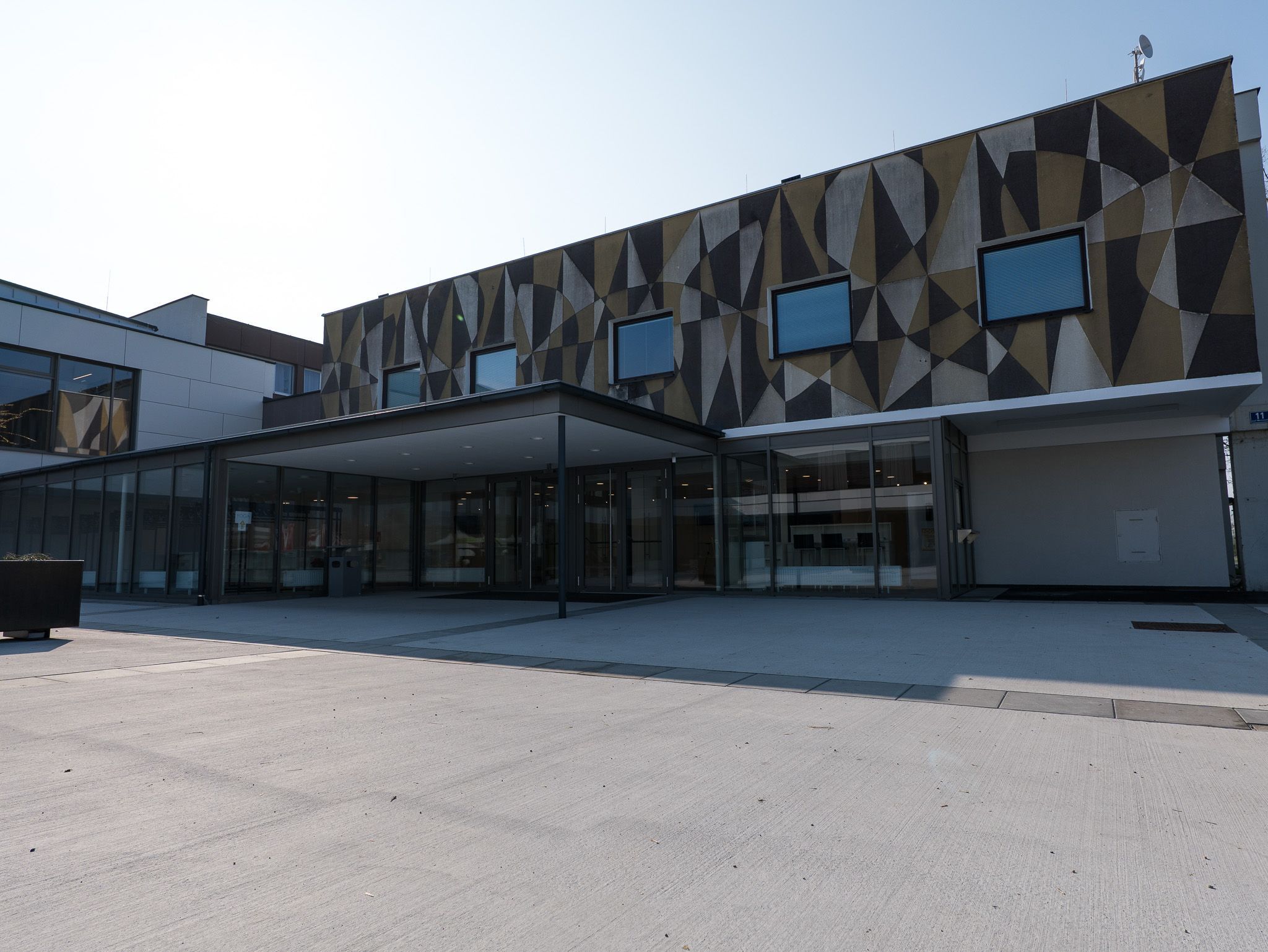 Egy modern épület külső nézete geometrikus mintákkal a homlokzaton.