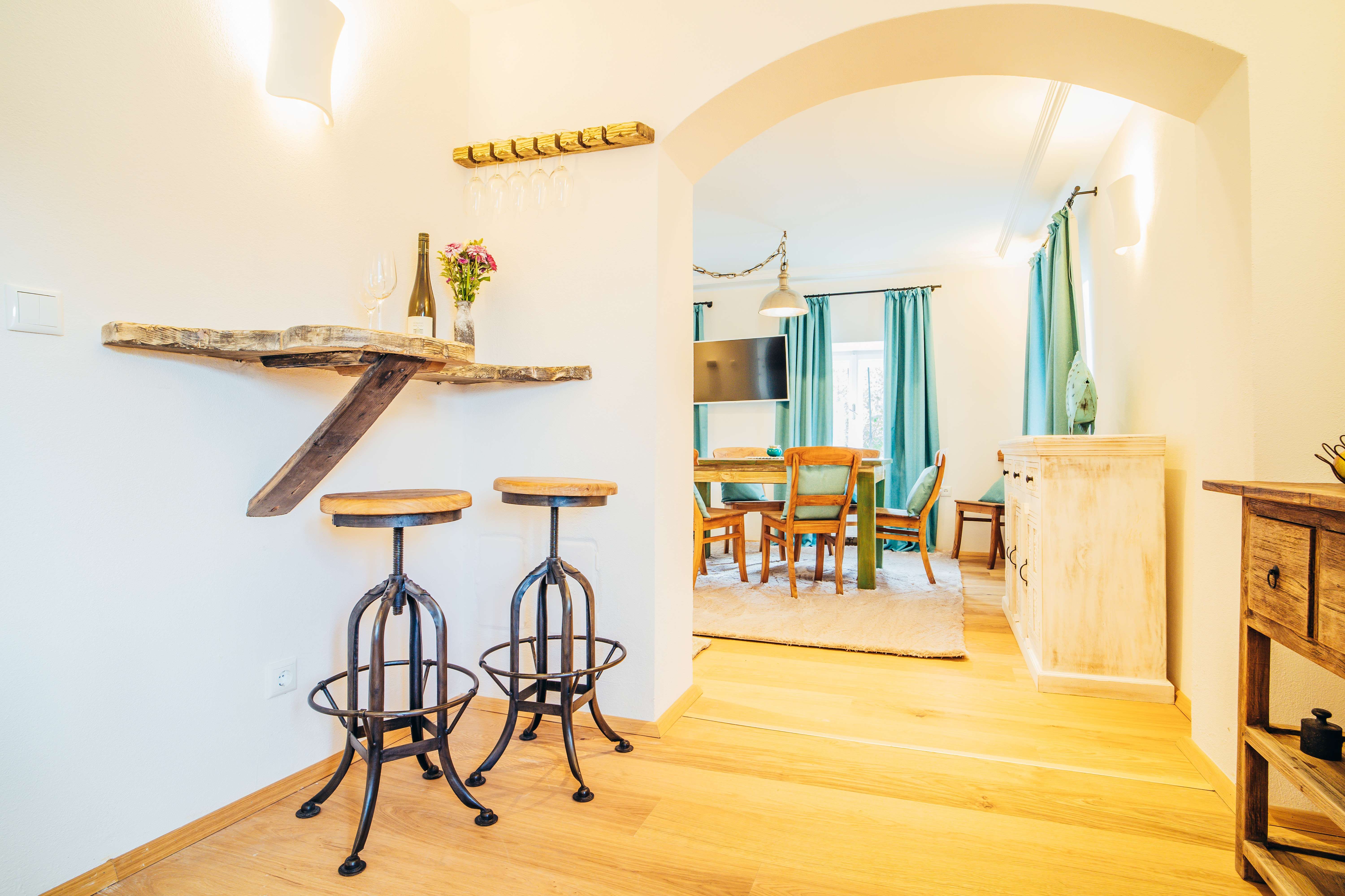 Hangulatos nappali fabútorokkal, bárszékekkel és étkezőasztallal.