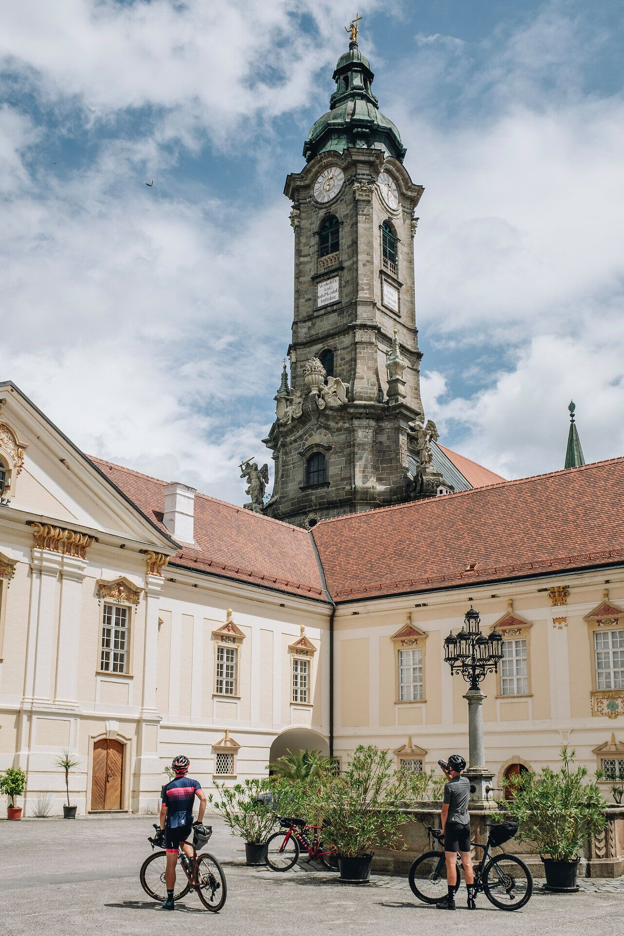 In der malerischen Kulisse des Zisterzienserstifts Zwettl genießen Radfahrer eine wohlverdiente Pause. Die beeindruckende Architektur und die sanften Hügel der Umgebung laden dazu ein, die Schönheit der Natur und die Ruhe des Ortes zu erleben. Hier, wo Geschichte und Landschaft harmonisch verschmelzen, wird jeder Moment zum unvergesslichen Erlebnis.