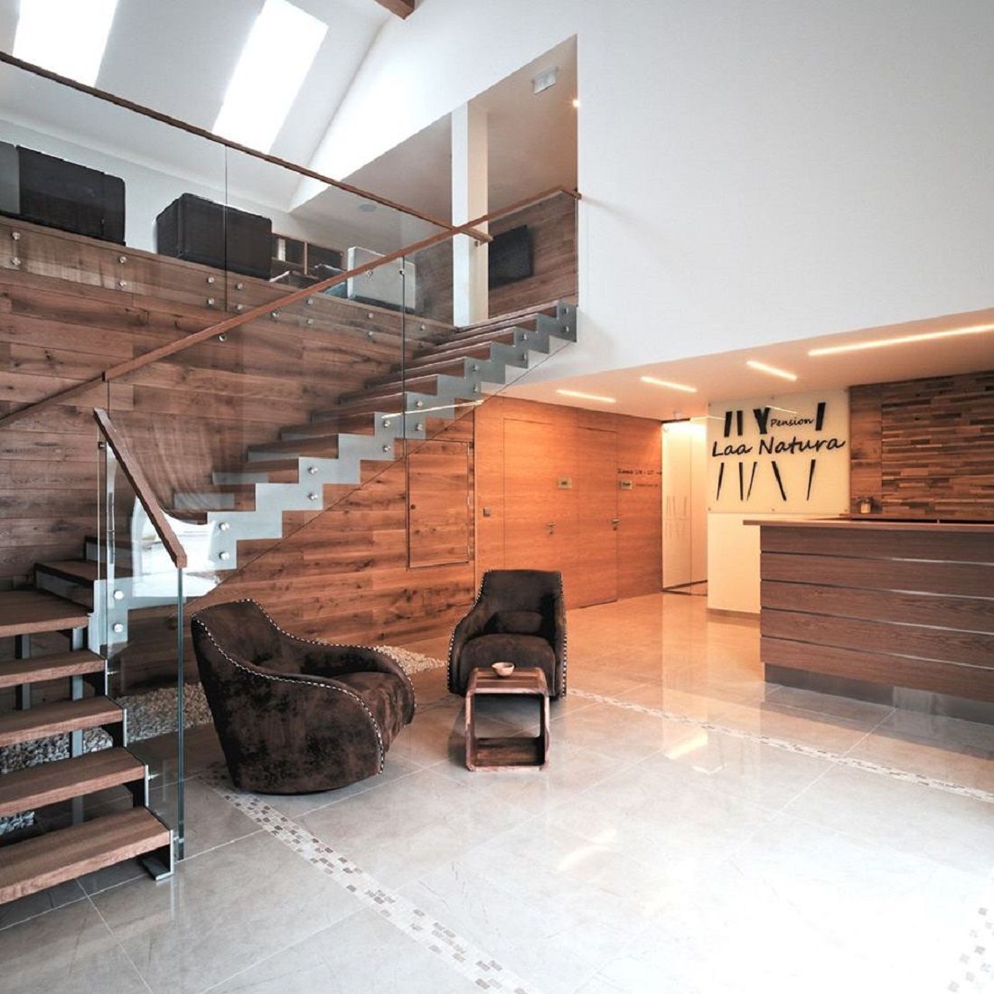 Modern bejárati rész faburkolattal, lépcsőházzal és recepcióval.