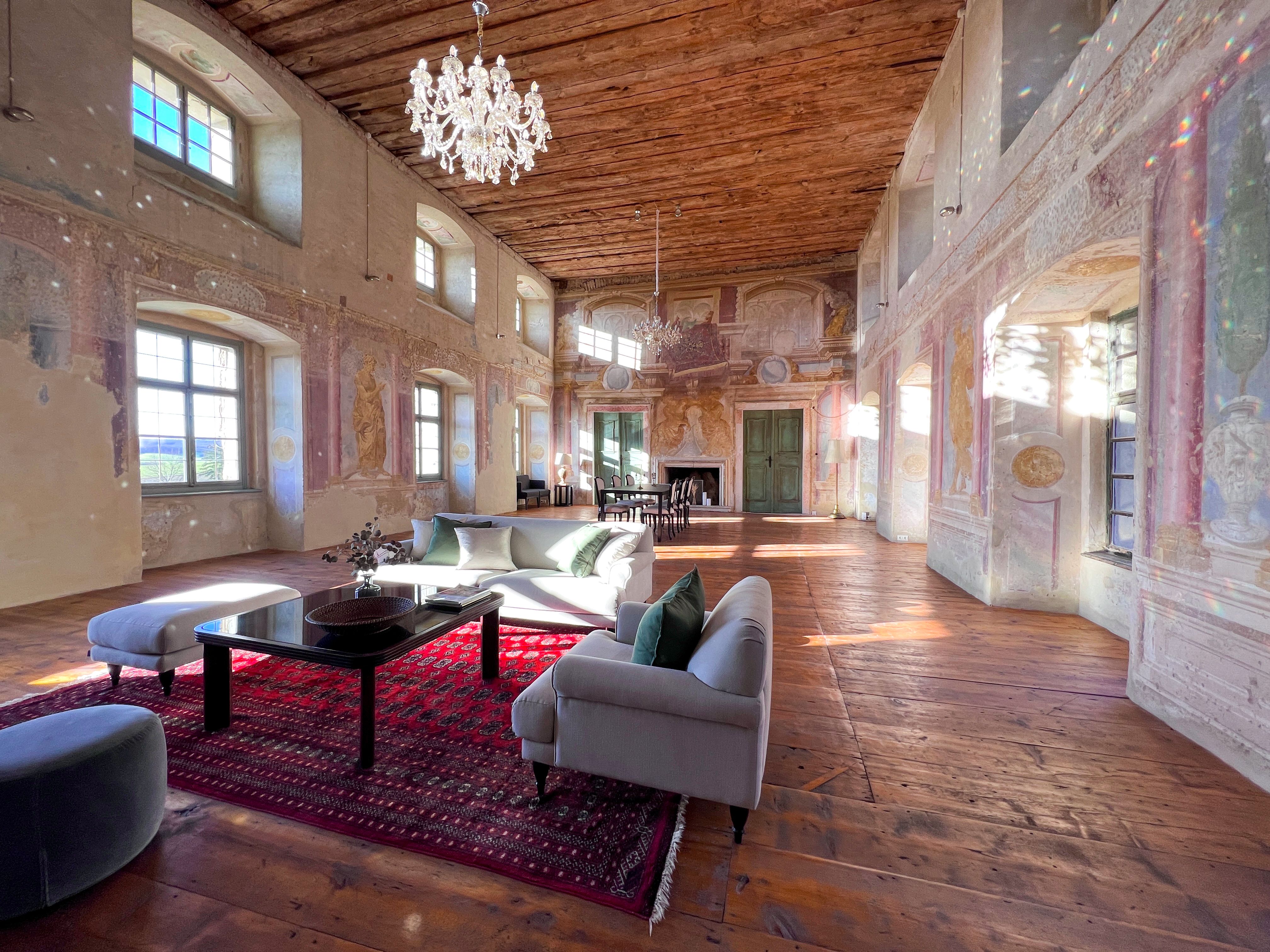 Történelmi bálterem, fapadlóval, festett falakkal és csillárral. A teremben modern bútorok és vörös szőnyeg található.