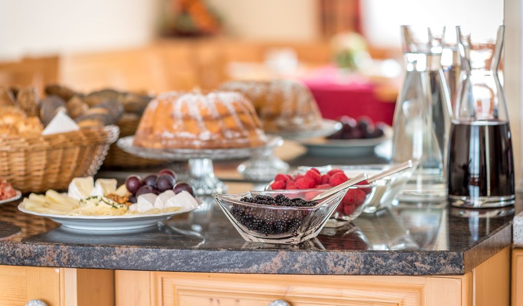 Svédasztalos reggeli süteményekkel, bogyós gyümölcsökkel, sajttálakkal és italokkal.