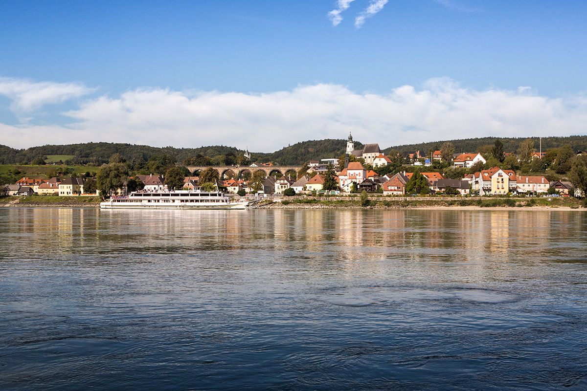 Emmersdorf an der Donau település panorámája egy hajóval a folyón.