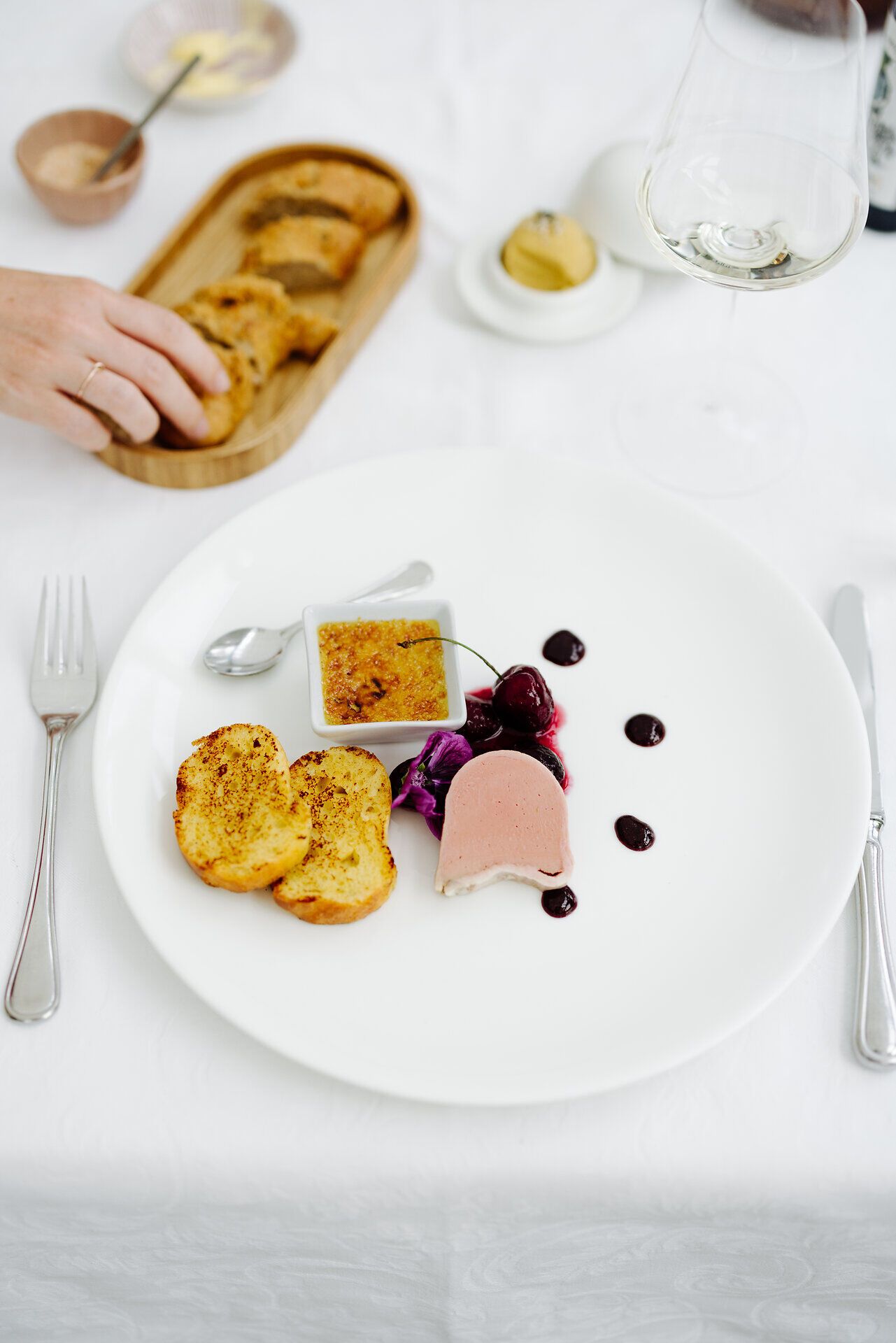 Ein kunstvoll angerichteter Teller vereint die Aromen der Region. Das Dinkel-Einkorn-Baguette harmoniert perfekt mit dem fermentierten Gemüse und verspricht ein unvergessliches Geschmackserlebnis. Genießen Sie die kulinarische Vielfalt in einem einladenden Ambiente.