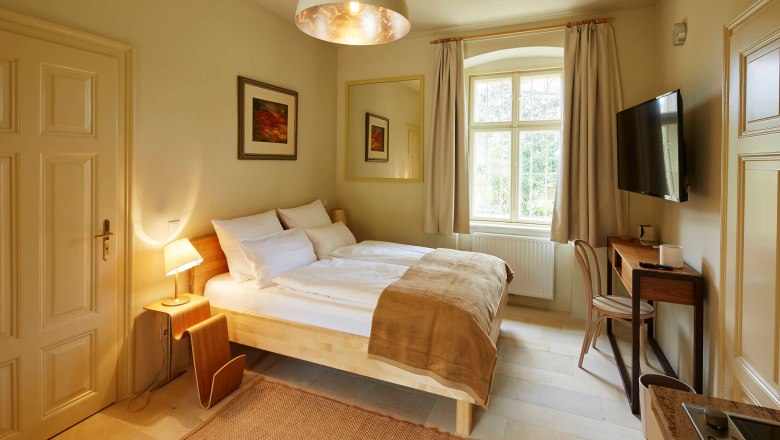 Hangulatos hálószoba franciaággyal, íróasztallal és nagy ablakkal.