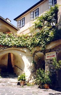 Történelmi épület növényekkel és boltívekkel.