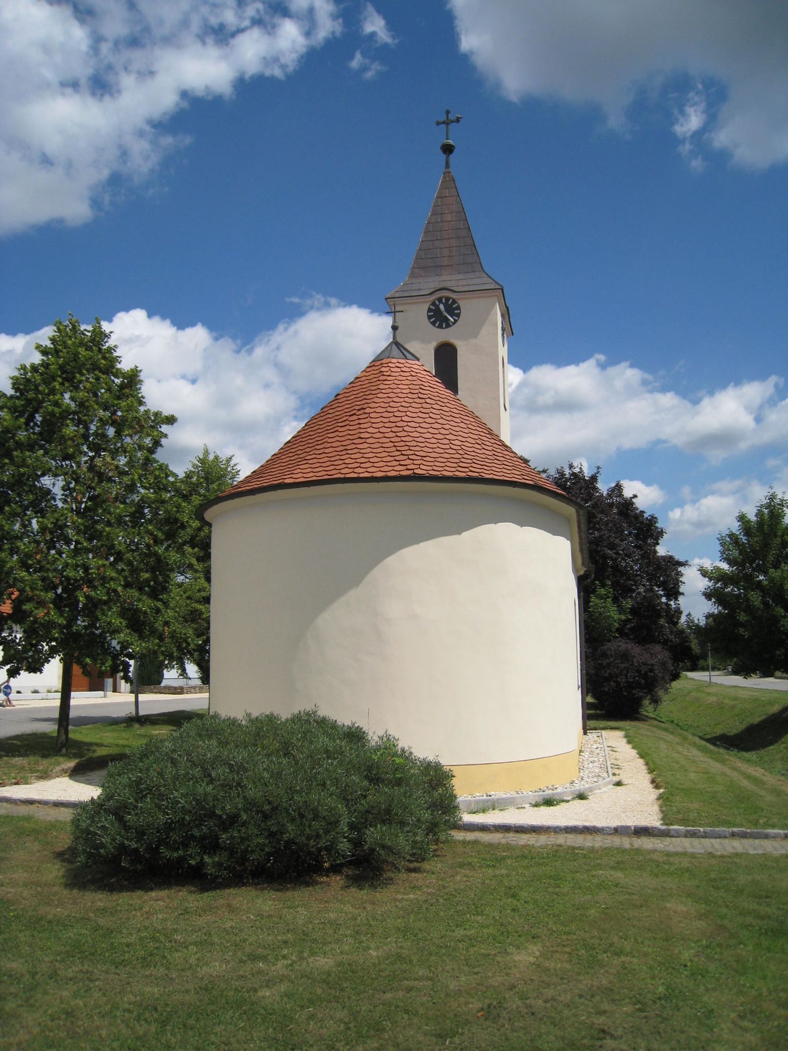 Szent Barbara-kápolna kerek tetővel és toronnyal a kék égbolt előtt.