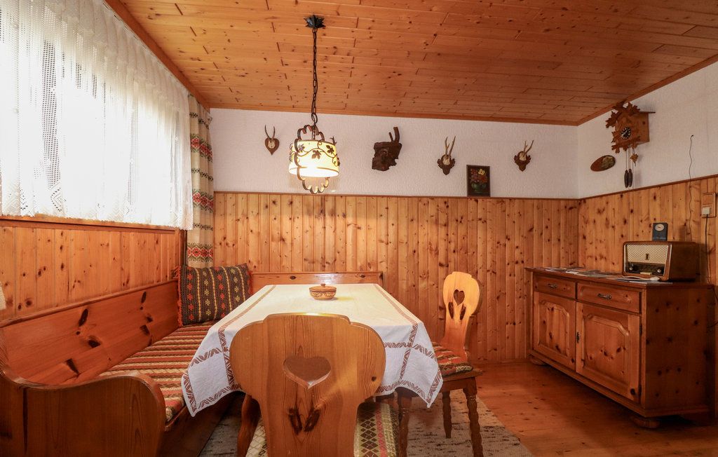 Hangulatos pinceszoba fabútorokkal, sarokpaddal, asztallal, rádióval és vadásztrófeákkal a falon.